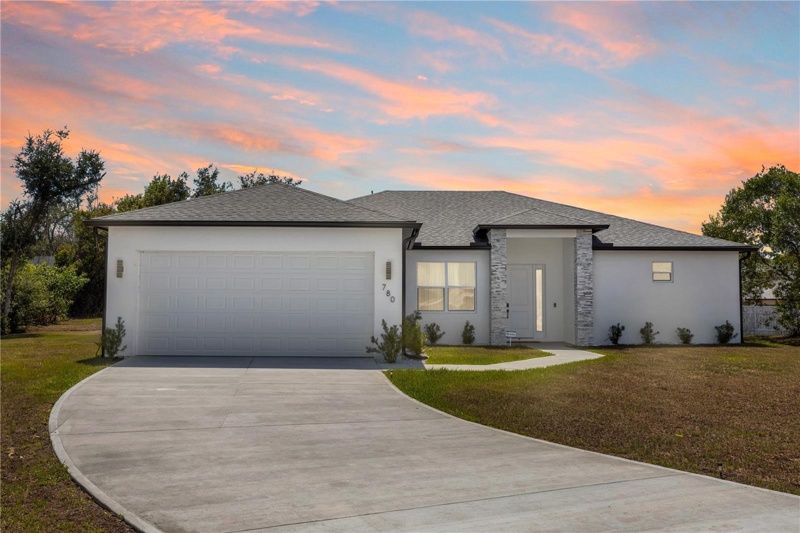 Perfect for multi-generational living, this practically brand-new home offers TWO primary suites, with 4 bedrooms PLUS a versatile flex room, ideal for a home office, media room, playroom, gym, or guest retreat. Built just last year and meticulously maintained, this beautifully upgraded 3-bathroom residence delivers the feel of new construction without the wait. Tucked away at the end of a quiet cul-de-sac in the heart of Deltona, this home combines modern elegance, thoughtful upgrades, and everyday comfort. From the moment you step inside, you’ll be impressed by the bright open-concept floor plan, abundant natural light, and seamless tile flooring throughout, creating a sleek and sophisticated feel. The spacious living area is highlighted by a custom built-in entertainment center, serving as a stylish focal point that’s perfect for entertaining or cozy nights in. The gourmet kitchen is truly the centerpiece of the home, featuring timeless white shaker cabinetry, luxurious quartz countertops, a marble-look backsplash, stainless steel appliances, designer gold hardware, and an oversized island complete with a bold brushed gold faucet. Designed with both style and functionality in mind, this kitchen is ideal for hosting gatherings or enjoying everyday living. Each of the spa-inspired bathrooms showcases artistic designer tile work, floating vanities, matte black and gold fixtures, and upscale finishes that create a custom luxury feel throughout the home. Step outside to enjoy Florida living at its finest under the extended covered lanai—perfect for outdoor dining, relaxing, or entertaining guests year-round. The epoxy-coated two-car garage adds durability while providing a polished, showroom-quality finish. Located in a desirable Deltona neighborhood close to shopping, dining, parks, schools, and major highways, this move-in-ready home offers the perfect combination of luxury, privacy, flexibility, and convenience. With modern upgrades, designer touches, and only one year of occupancy, this home truly feels practically brand new. Schedule your private showing today before this home is gone!