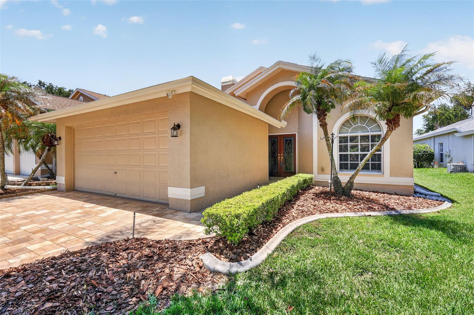 Welcome to Kingsmill in the highly sought-after East Lake Woodlands community! This beautifully maintained waterfront home features 3 bedrooms, 2 bathrooms, and a 2-car garage, and has been lovingly cared for by its original owner. From the moment you arrive, you'll be impressed by the home's private cul-de-sac location and newly paved driveway. Step inside to discover luxury vinyl flooring that flows seamlessly throughout the main living areas and bedrooms. High ceilings and natural light create an open, airy atmosphere throughout the home. The spacious living and dining room combination is highlighted by a cozy fireplace, creating the perfect setting for both everyday living and entertaining. The kitchen features wood cabinetry, solid-surface countertops, a tile backsplash, brand new matching GE stainless steel appliances, and a breakfast nook overlooking the water. A full pocket sliding glass door opens to the lanai, allowing you to fully enjoy the tranquil lake views. The primary suite is a true retreat, offering water views and private access to the screened porch through sliding glass doors. The ensuite bathroom features dual vanities, a garden tub, a walk-in tiled shower, tile flooring, and two walk-in closets. The secondary bedrooms provide ample storage with built-in closets, while the guest bathroom includes tile flooring, a wood vanity with a solid-surface countertop, and a walk-in tiled shower. Additional features include an indoor laundry room with brand new washer and dryer included, a freshly painted garage floor, a 2021 roof, 2026 water heater, and 2017 HVAC system. Enjoy maintenance-free living with low monthly HOA fees that include lawn maintenance and trash service. Located within the gated East Lake Woodlands community, residents have the option to join Ardea Country Club, which offers exceptional amenities including two championship 18-hole golf courses, a fitness center, restaurant, swimming pools, tennis courts, racquet sports facilities, and more. Conveniently located near shopping, dining, airports, and some of Florida's most beautiful beaches, this home offers the perfect combination of comfort, convenience, and resort-style living. Don't miss this opportunity—schedule your private showing today!