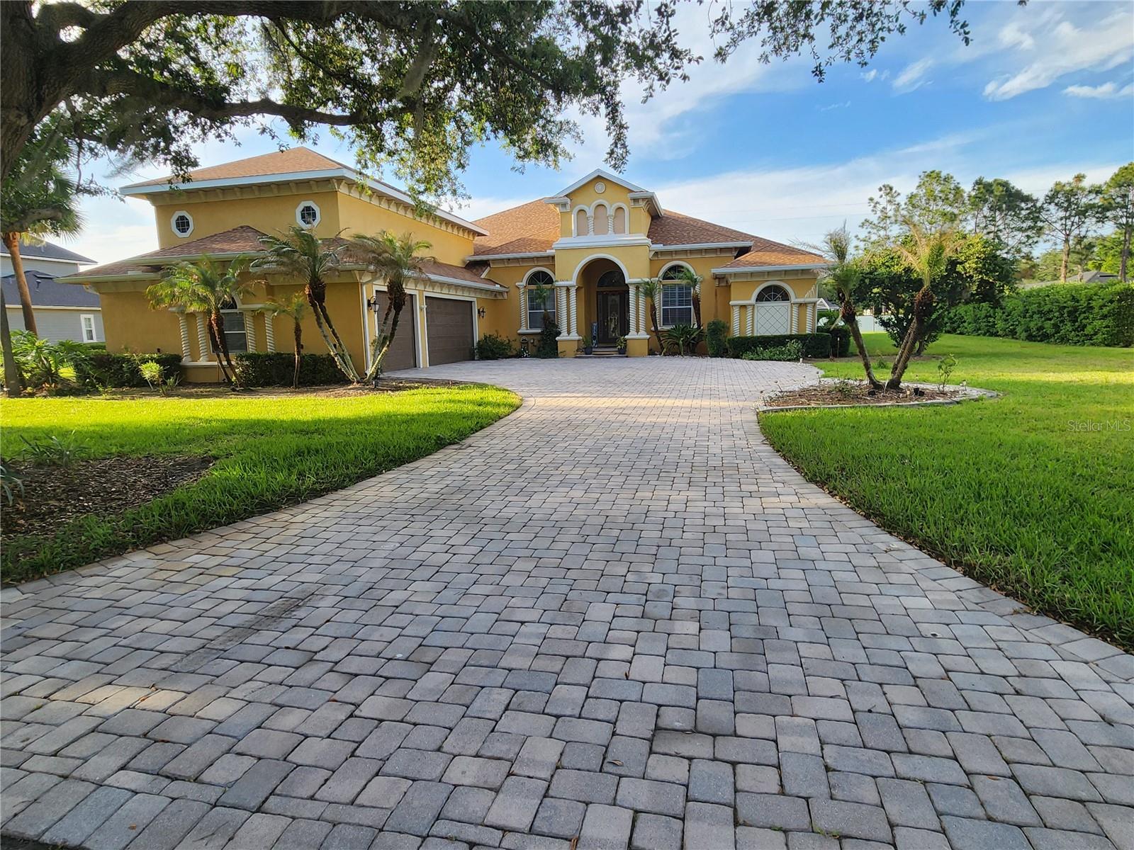 Discover refined living in Wyndsor at Lake Winterset, one of Winter Haven’s premier gated communities. Set on a half-acre lot, this beautifully maintained 5-bedroom, 5-bathroom residence blends timeless craftsmanship with thoughtful updates and an impressive amount of living space. Step inside to soaring ceilings, architectural arches, decorative pillars, crown molding, and tray ceilings that create an immediate sense of grandeur. The formal living and dining rooms flow effortlessly into the main living areas, where 16x16 tile and luxury plank vinyl flooring with water-proof add both style and durability. The spacious kitchen is designed for everyday living and entertaining, featuring a large island, stainless steel appliances, and built-in oven and microwave. It opens to a warm and inviting great room complete with a gas fireplace and custom built-ins. A dedicated office and two additional living areas provide flexibility for work, relaxation, or extended generations. The primary suite is a private retreat with a double-door entry foyer, two walk-in closets, and room for a sitting or desk area. The spa-like en-suite bath includes a dual-head shower, Jacuzzi tub, granite counters, double sinks, and a separate vanity. Four additional bedrooms — each with its own private bath — are thoughtfully positioned on the opposite side of the home for maximum privacy. The upstairs suite offers versatility as a second primary, media room, or game room. Enjoy Florida living on the expansive 1,000 sq ft screened lanai, fully under roof and pre-plumbed and wired for an outdoor kitchen. Excellent for quiet evenings or large gatherings. Additional highlights include a 3-car garage with storage room and a tankless hot water system. Major updates include a new roof (2022) and two HVAC units (2017). Located minutes from Legoland and within easy reach of both coasts, major attractions, shopping, and dining, this home delivers luxury, space, and convenience in one of the area’s most desirable neighborhoods.