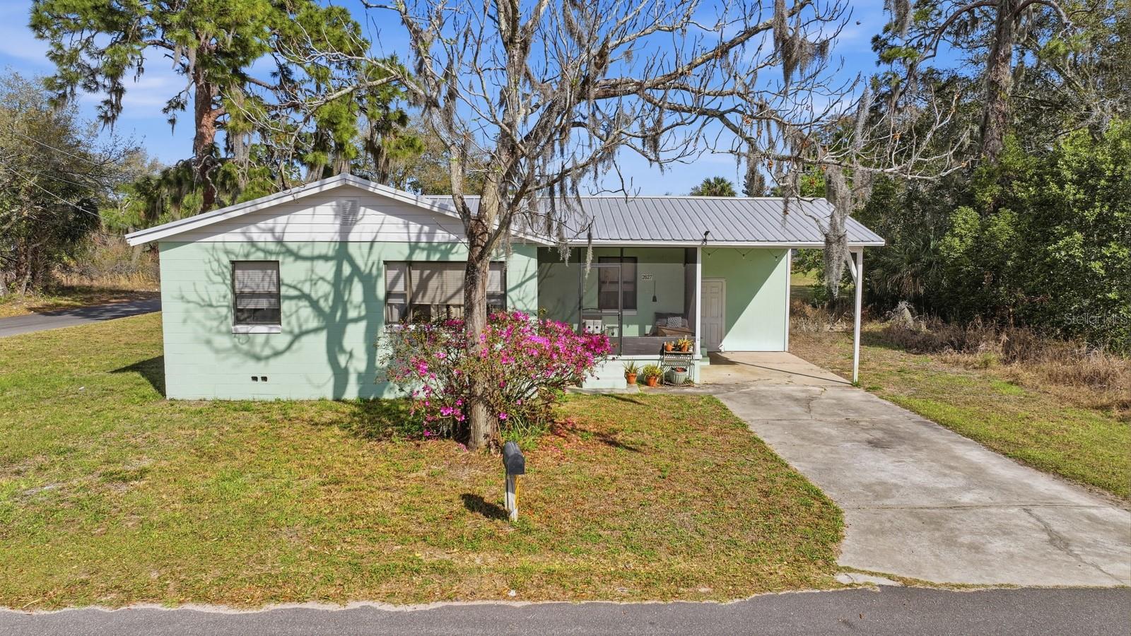 SELLER IS HIGHLY MOTIVATED! Welcome to 2627 Myrtle Ave in Mims, Florida, a charming and well-maintained home situated on a spacious corner lot with plenty of room to enjoy the peaceful surroundings. This inviting property features bright, open living spaces with abundant natural light from multiple windows, creating a warm and welcoming atmosphere throughout. The living room flows seamlessly into the dining area and kitchen, making it ideal for both everyday living and entertaining. The kitchen offers ample cabinetry, countertop space, and a convenient layout, perfect for preparing meals while staying connected to the rest of the home. Several flexible rooms provide options for bedrooms, a home office, or hobby space, allowing the home to adapt to your needs. Step outside to enjoy the large yard with mature trees and open green space, offering endless possibilities for gardening, outdoor activities, or future improvements. The home also features a covered carport and screened front porch, providing comfortable outdoor living areas. Additional highlights include a NEW HVAC system for peace of mind, updated flooring, bright interior finishes, and plenty of natural light throughout. Conveniently located with easy access to US-1, Titusville, Kennedy Space Center, and the Space Coast, this home offers the perfect blend of quiet living while still being close to shopping, dining, and major employers. Whether you're looking for your first home, downsizing, or investing, this property is full of potential and ready for its next owner.