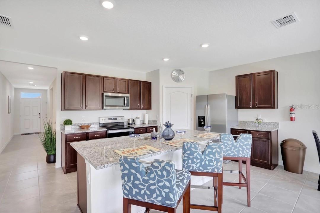 Welcome to this beautifully maintained, nearly new 4-BEDROOM, 2-BATHROOM home in the desirable INMAN GROVES community! Built in 2023 by D.R. Horton, this popular CALI FLOOR PLAN offers 1,828 square feet of thoughtfully designed living space with an open-concept layout perfect for both everyday living and entertaining.  The spacious kitchen features SOLID SURFACE COUNTERTOPS, STAINLESS STEEL APPLIANCES, abundant cabinetry, a large island with seating, and overlooks the dining and living areas, creating a bright and inviting gathering space. The private owner's suite includes a generous walk-in closet and an en-suite bath, while three additional bedrooms provide flexibility for family, guests, or a home office.  Additional highlights include ceramic tile flooring in the main living areas, an inside laundry room, energy-efficient construction, smart home features, a two-car attached garage, and an irrigation system. Step outside to enjoy the backyard with plenty of space to relax, entertain, or create your own outdoor oasis. Conveniently located near shopping, restaurants, schools, medical facilities, and major highways, this home also offers easy access to Downtown Winter Haven, LEGOLAND Florida Resort, and ORLANDO or TAMPA via nearby US-27 and I-4. Don't miss this opportunity to own a move-in-ready home in one of Winter Haven's growing communities!