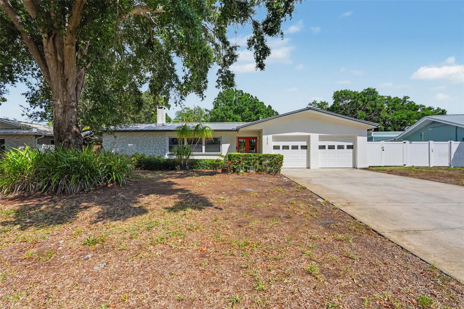 Virtually Staged. Welcome to this beautifully maintained Mid-Century Modern home nestled on a quiet street with no through traffic in the highly desirable Jungle Country Club neighborhood of St. Petersburg. Situated on a .35-acre lot and thoughtfully updated with a 2024 AC, 2016 metal roof, and newer impact windows and sliding glass doors (excluding the garage door), this three-bedroom, two-bathroom, plus a dedicated office that could be a 4th bedroom, residence offers timeless character paired with modern comfort. Step inside through the welcoming foyer, where a spacious front living room with a cozy wood-burning fireplace greets you. The heart of the home features an open family room, dining area, and kitchen, creating the perfect space for everyday living and entertaining. The kitchen is beautifully appointed with quartz countertops, abundant prep space, stainless steel appliances, natural gas cooking, attractive cabinetry, and a window above the sink overlooking the backyard. Modern light fixtures add a fresh touch throughout the main living spaces, while tile flooring provides durability and easy maintenance. The bedrooms feature parquet flooring, adding warmth and character. The spacious primary suite features a walk-in closet with custom organizers, private en-suite bathroom, and sliding glass doors leading directly to the backyard. Two additional generously sized bedrooms, both with ceiling fans, share a full bathroom with a tub/shower combination. Outside, the fully fenced backyard offers endless possibilities. Relax on the patio, take advantage of the storage shed and additional covered parking ideal for a boat or recreational vehicles, or bring your vision to life with the included plans for a future pool to create your own private Florida oasis. A two-car garage provides even more storage and convenience. Ideally located just minutes from parks, shopping, and dining, this home is less than 10 minutes from Treasure Island Beach and approximately 20 minutes from vibrant Downtown St. Petersburg, where you'll enjoy waterfront parks, festivals, restaurants, museums, and year-round events. This is a rare opportunity to own a move-in-ready home in one of St. Petersburg's most sought-after neighborhoods. Schedule your showing today!