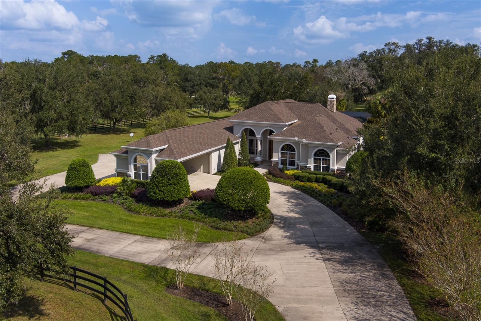 Seller will consider seller financing to qualified buyers. - Situated on 21+ acres in Brookfield Annex, Reddick, FL, this meticulously maintained equestrian property is under 15 minutes from both the World Equestrian Center and HITS. The circular drive leads to a portico and 2-car garage, welcoming you to a spacious 4-bedroom, 4.5-bathroom home with high ceilings and tile flooring throughout. The master suite and guest suites provide ample comfort, while the family room opens to a screened-in pool and outdoor living area, ideal for entertaining. The landscape, dotted with majestic live oaks, includes a tranquil pond that adds to the property’s natural charm. Equestrian amenities feature a round pen and an 8-stall block barn with a feed/tack room, along with an upstairs guest or farm manager’s quarters with 2 bedrooms, 2 bathrooms, and a screened porch overlooking the pond. A 5-bay equipment garage offers extensive storage options.