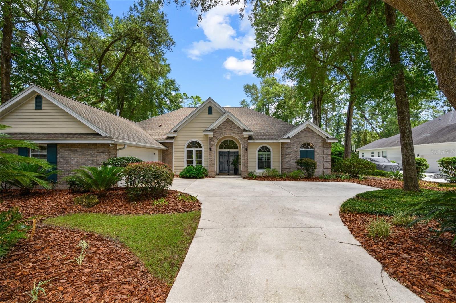 Filled with natural light and located on a private lot backing to one of Haile Plantation’s largest common areas, this 3,000 square foot Barry Bullard-built home offers four bedrooms, three-and-a-half bathrooms, a study, and a desirable three-way split floor plan. Large windows throughout the home, including a dramatic picture window in the family room, provide beautiful views of the private backyard and expansive green space beyond. A spacious foyer opens into the main living areas, where beautiful wood floors flow throughout the living room, dining room, family room, kitchen and hallways. Straight ahead is the formal living room where French doors lead to the screened lanai, pool, spa, and backyard. To the left is the formal dining room with a tray ceiling and elegant chandelier. To the right, the study features a large window with plantation shutters and a closet. Just off the main living areas is a beautifully renovated powder room with convenient access to the pool. The completely renovated kitchen features quartz countertops, wood cabinetry, a center island, stainless steel appliances including an induction cooktop, double ovens, two dishwashers, a wine refrigerator, and a walk-in pantry. The kitchen opens to the family room, where a gas fireplace with custom built-in shelving creates a perfect gathering space. The primary suite offers space for a sitting area and features a large picture window overlooking the pool, spa, and backyard. The completely renovated bathroom includes a large walk-in shower, a 42-inch dual-sink vanity, LED lighted mirrors, a built-in towel warming bar, and two walk-in closets. Two secondary bedrooms share a hall bathroom, while a fourth bedroom has its own private bath and can be separated from the rest of the home, making it ideal for guests or multi-generational living. The spacious screened lanai is already plumbed with natural gas for your grill and overlooks the pool, spa, and private backyard. The home also features a spacious two-car garage with plenty of room for vehicles, storage or workspace. The home is just a short distance from Chiles Elementary School and Hawkstone Country Club. Haile Plantation offers miles of walking trails, parks, playgrounds, basketball courts, and the Village Center with its shops, restaurants, and Saturday farmers market. Optional membership at Hawkstone Country Club provides access to golf, tennis, pickleball, a fitness center, dining, and two swimming pools.