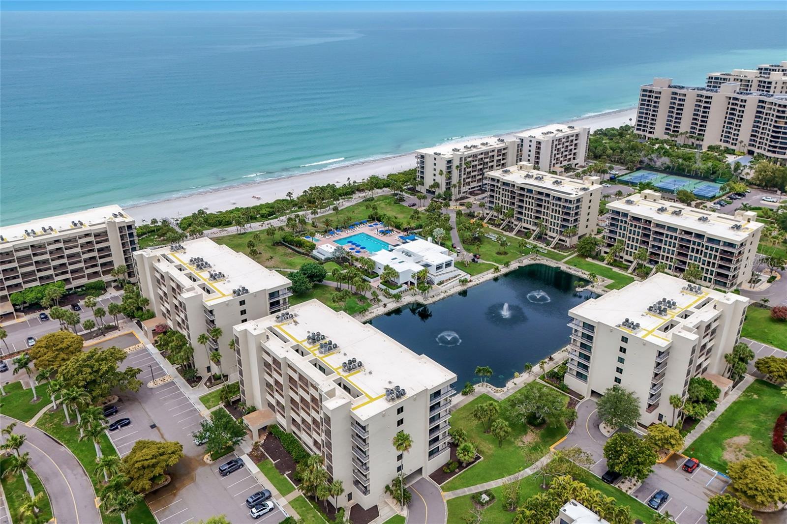 A rare private walk-down residence in the highly sought-after Beachplace community on Longboat Key. This property offers the convenience of direct terrace access to the beautifully landscaped grounds below, overlooking a serene pond with fountains and offering a charming peekaboo view of the Gulf. Spacious and largely original, presenting the perfect canvas for a buyer to customize and create their ideal coastal retreat while enjoying the exceptional location and layout. The light-filled interior features an open living and dining area with walls of glass that connect seamlessly to the outdoor living space, creating an inviting indoor-outdoor lifestyle just moments from the beach. The split-bedroom floor plan offers privacy and functionality, while the terrace provides a peaceful setting to relax and enjoy the lush tropical surroundings. Whether updating immediately or renovating over time, this residence offers tremendous potential within one of Longboat Key’s premier Gulf-front communities. Beachplace is renowned for its resort-style amenities and beautifully maintained grounds. Residents enjoy 24-hour guard-gated entry, on-site management, a clubhouse, fitness center, tennis and pickleball courts, heated swimming pool and spa, private beach access, walking paths, and expansive tropical landscaping throughout the community. Ideally positioned on the south end of Longboat Key, Beachplace is just minutes from the fine dining, boutiques, and waterfront charm of St. Armands Circle, as well as downtown Sarasota’s cultural attractions, marinas, golf clubs, and world-class beaches.
Whether you are searching for a seasonal getaway, investment opportunity, or full-time coastal residence, this property presents exceptional value and the opportunity to create a personalized beachfront retreat in one of Longboat Key’s most desirable locations.