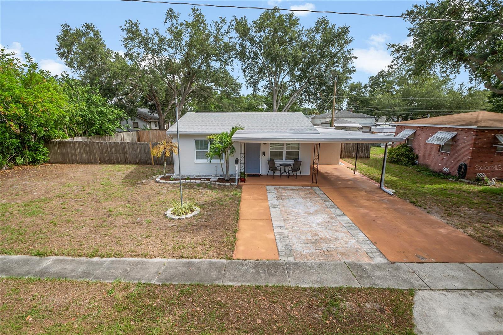Welcome home to this charming 3-bedroom, 1- bathroom, 1- car carport home on a double lot in Sunny St. Petersburg! This residence is centrally located with easy access to the Gulf Beaches and is just minutes to downtown!  Step inside and fall in love with this light and bright gem, it features an open living area, split bedrooms, and an inside laundry room. Updates to this home include tile flooring throughout, double pane windows, fully updated bathroom and a partially updated kitchen. The roof was new in 2020/flat roof 2024, A/C in 2018, water heater 2026, and the electrical panel has been updated. Step out back and see where this home really shines, there is a massive back yard with full fencing and a shed for all your lawn storage needs! This house sits on 2 lots, and the city is friendly for additional dwelling units/ tiny homes or use the space to store your boat or R/V! Hurry, do not miss your chance to own this home, it will not last long! NO FLOOD ZONE!!!!