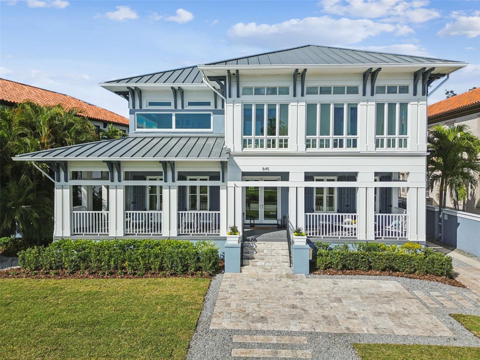 Beautifully situated along classic Bayshore Boulevard, this refined waterfront residence has been thoughtfully reimagined through a comprehensive 2025 renovation.  Incredible waterfront views enhance the home’s sense of scale and flow, creating an inviting setting for both comfortable living and entertaining. A fully reconstructed wraparound porch sets an inviting arrival, complete with custom columns, ceilings, architectural decking, and curated landscaping accented by tailored exterior lighting. French doors open to a grand foyer, where soaring ceilings, crown molding, and abundant natural light establish an immediate sense of elegance. Formal sitting and dining rooms flank the entry, thoughtfully positioned to flow to the outdoors—most notably from the dining room, where French doors lead to a side porch and alfresco dining deck overlooking the pool. A discreet butler’s door connects to the newly completed kitchen, featuring floor-to-ceiling custom cabinetry, a dramatic quartzite waterfall island, and never-used Thermador appliances. The rear of the home opens into a relaxed yet sophisticated gathering space, uniting the kitchen, breakfast area, and family room anchored by a gas-burning fireplace, ideal for both intimate evenings and larger gatherings. An elevator, designer powder bath, and media storage complete the main level. Upstairs, a split-bedroom layout offers privacy and versatility. A sunlit loft at the front of the home is wrapped in windows with water views, creating a flexible living space filled with natural light. The primary suite is a true retreat, featuring an enclosed sunporch, perfect for morning coffee or quiet moments, along with two custom walk-in closets. The completely reimagined primary bath evokes a spa-like experience with a marble-clad walk-in shower with rainhead, soaking tub framed by a marble accent wall, dual vanities with updated lighting, and a private water closet. Three additional bedrooms complete the upper level, including two sharing a well-appointed Jack-and-Jill bath with custom walk-in closets, and a private rear en-suite bedroom. Impact-rated second-floor windows installed in 2025 enhance comfort and peace of mind, and the elevator services this level as well. Outdoors, the property transforms into a private resort setting with a heated pool and spa, new equipment and resurfacing, travertine pavers, lush landscaping, an outdoor shower, and a pool bath with marble finishes. Completing the offering is a rare drive-through configuration from Bayshore Boulevard to the rear alley and garage experience with two-car parking, custom cabinetry, a dedicated workspace, wine refrigeration, and an open-air storage loft accessed by the elevator. Additional refinements include an integrated speaker system, automated lighting and irrigation, a security system, gated entry. This is a timeless expression of modern luxury. An exceptional waterfront home that lives beautifully and entertains effortlessly in one of Tampa’s most distinguished settings.