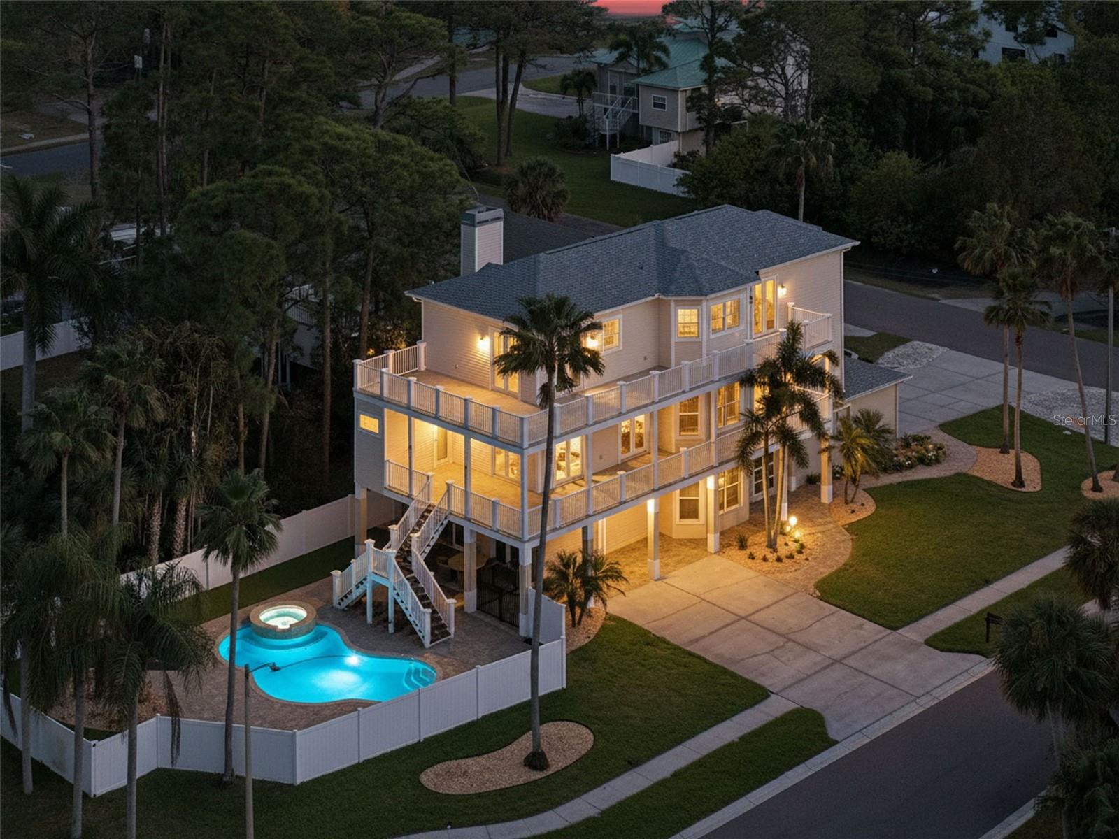 Coastal residence with views of Sutherland Bayou, located on a quiet cul-de-sac of six homes in the fabulous Ozona area of Palm Harbor. This Key West–inspired home offers over 1,800 square feet of wraparound balconies across two levels designed to capture water views and coastal breezes. The seller has invested in recent, significant upgrades, including all-new Miami-Dade triple-locking Category 5 impact-rated French doors, white oak engineered hardwood flooring and stair treads throughout, a modern cable stair railing system, polyaspartic flooring in both two-car garages, complete interior repaint including garages and gym, updated living room finishes, new roof (2023), three new AC systems (2023 and 2024), new hot water heater (2024), and new pool pump (2024). The first floor is solid block construction. The home offers 4 bedrooms, 3.5 baths, a dedicated office/den, and an oversized 4-car garage. The ground level features a foyer with high ceilings and a versatile bonus space (not included in living square footage) suitable for gym, studio, or additional living area, along with access to two separate two-car garages, one pre-wired for EV charging. The main living level includes an updated kitchen with custom wood cabinetry, pull-out storage, quartz countertops and backsplash, stainless appliances, induction cooktop, breakfast bar, and ample prep space. The kitchen opens to the great room with soaring 10-foot ceilings and a wood-burning fireplace. Impact French doors and large windows with plantation shutters provide balcony access and partial water views. This level also includes a guest bedroom, powder room, private office/den with balcony access, and a full bath with pool access. The top-floor primary suite features double walk-in closets, motorized shades, and a bath with soaking tub, glass-enclosed shower, and dual vanities. Two additional guest bedrooms, an updated full bath, and access to the upper balcony complete the third floor. The backyard includes a saltwater pool and spa with new pure salt chlorinator, artificial turf, vinyl fencing, and a solar-assisted water heater. Transferable flood insurance is $725 per year. No HOA. Oyster Point is a golf cart–friendly community near waterfront dining, parks, marinas, downtown Palm Harbor, Honeymoon Island, Clearwater Beach, and Innisbrook Golf Resort.