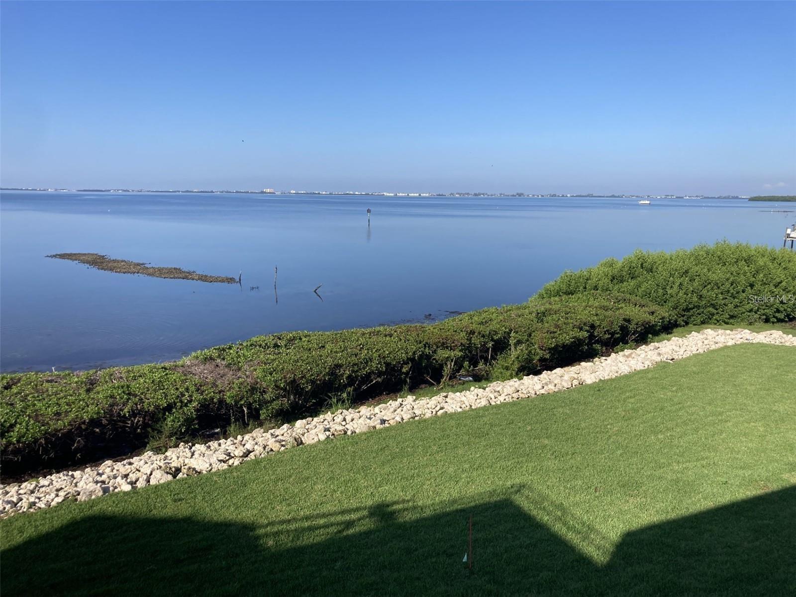 Absolutely fantastic views of Sarasota Bay from this spacious two bedroom - two bath condo located in the beautiful tropical Wild Oak Bay.  There are high impact windows and sliders throughout.  The condo is beautifully appointed with high gloss tile floors, remodeled kitchen with Kitchen Maid cabinets, granite countertops, stainless steel appliances and attractive back splash plus tray ceiling with recessed lighting and ceiling fan.  The master bathroom has an updated shower plus a walk-in closet  plus another set of closets, and most importantly a set of slider doors with a view of the bay.  There is a large glass enclosed lanai with new remote control blinds and a walk-in closet which can be used as an office or storage.  In front there is an open patio - perfect for seating and plants! Move-in condition! Close to the elevator.  There is a carport plus quest parking.  New roof in 2025.  New drainage system in back yard to counteract future storms.  Owner has paid all assessments.  The condo is located in the IMG Country Club area which features an 18 hole regulation size semi-private golf course and clubhouse/grill room overlooking Sarasota Bay.  There is also a tennis club in the area.  Located near schools, shopping, grocery stores and minutes away from the airport and Sarasota.  Approximately 8 miles to the beach.  An all age condo and two pets allowed.