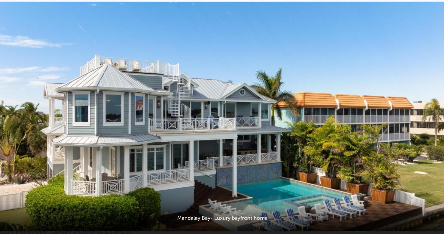 Experience the pinnacle of waterfront living in this extraordinary custom bayfront estate, offered fully turn-key and professionally decorated. Encompassing 6,000 square feet of living space and 8,747 square feet under roof, this architectural masterpiece delivers breathtaking 360-degree panoramic views of the Gulf of Mexico and The Inter Coastal Water Way,through dramatic floor-to-ceiling glass walls.  Designed for both grand entertaining and relaxed coastal living, the residence features 7 spacious bedrooms, 5 full bathrooms, and 2 half baths. Two fully equipped gourmet kitchens showcase solid wood custom cabinetry, striking tile backsplashes, oversized marble countertops with expansive islands, and high-end stainless-steel appliances, including gas ranges—perfect for hosting family and guests with ease.  The luxurious primary suite offers a serene retreat with an elegant en-suite bath, complete with a soaking tub and walk-in steam shower. Additional highlights include an elevator, private theater room and a game room with pool table, creating exceptional indoor entertainment spaces.  Outdoor living is elevated to resort caliber with expansive balconies featuring a built-in outdoor kitchen, bar, and dining area—ideal for sunset gatherings. The spectacular heated pool boasts a waterfall feature, sun shelf, and a spa with custom lighting, all overlooking tranquil bay waters.
Boating enthusiasts will appreciate the private dock, two boat lifts, and jet ski lift, while a rooftop deck offers yet another vantage point for unforgettable views and stargazing.  Recent upgrades include five new central HVAC systems, new flooring, new garage doors, new poolside tile, fresh interior and exterior paint, designer wallpaper, updated light fixtures, and new washer and dryer—ensuring effortless, worry-free ownership.  This property is ideally suited for weekly short-term rentals, offering a rare opportunity to combine luxury ownership with strong income potential.  Its premier bayfront location, expansive sleeping capacity, resort style amenities, and turnkey, professionally decorated interiors make it highly desirable for high end vacation rentals and multi-family retreats on Anna Maria Island.  This is a rare opportunity to own a one-of-a- kind luxury home with timeless design, modern upgrades, and unparalleled water views converge.