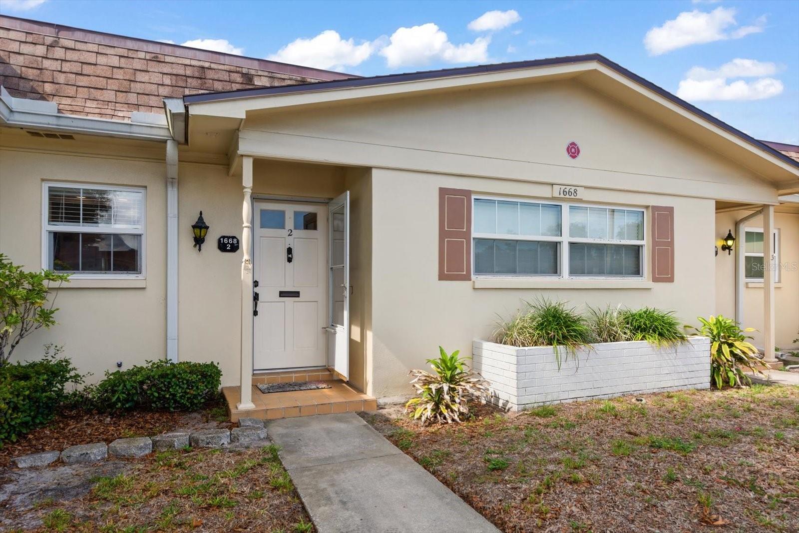 This well-maintained, move-in-ready deluxe villa offers comfortable, low-maintenance living in a vibrant 55+ Clearwater community. With 974 square feet of living space, the thoughtfully designed floor plan flows seamlessly from the kitchen to the dining area, into the living room, and out to the enclosed porch, creating an inviting space for everyday living and entertaining. The spacious bedroom and full bathroom are conveniently situated just off the main living area.  Inside, you'll find numerous updates, including energy-efficient windows, updated laminate flooring throughout the living areas, tile flooring in the kitchen and bathroom, wide blinds, and updated appliances, including the stove and refrigerator. The electrical panel has also been upgraded for added peace of mind.  One of the villa's standout features is the private in-unit laundry—a rare convenience within the community. The enclosed porch houses a stacked washer and dryer, providing the ease and comfort that many buyers seek.  Nature lovers will appreciate being just five minutes from Eagle Lake Park, a 162-acre preserve featuring walking trails, scenic boardwalks through restored wetlands, fishing areas, picnic shelters, a playground, and separate dog parks for large and small dogs. Everyday conveniences are equally close, with shopping, dining, and retail options just minutes away.  Residents enjoy an array of community amenities, including a clubhouse, swimming pool, shuffleboard courts, billiards room, card room, library, community car wash station, and ample guest parking.  Whether you're seeking a seasonal getaway or a full-time residence, this villa offers an exceptional combination of comfort, convenience, and an active Florida lifestyle. Schedule your private showing today and discover all that this wonderful home has to offer.