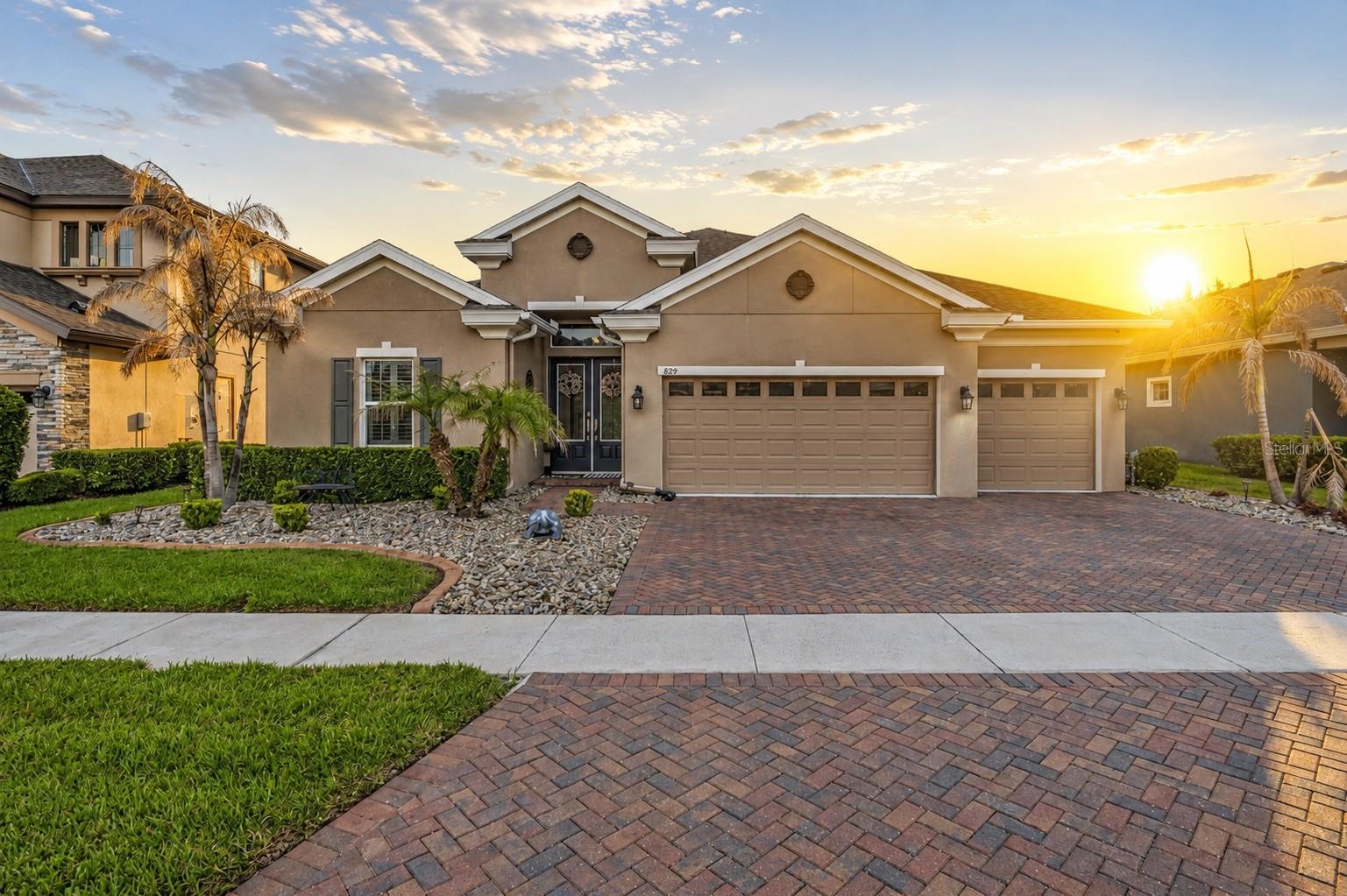Welcome to an exceptional home in the prestigious, guard-gated community of LakeShore Ranch, where luxury, comfort, and resort-style living come together seamlessly. Built in 2019 and thoughtfully designed with over 2,500 square feet of living space, this residence immediately impresses with its elegant architectural details, soaring ceilings, crown molding, and open-concept layout that creates a sense of both grandeur and warmth.As you enter, your eyes are naturally drawn through the expansive living area to the stunning outdoor retreat beyond. The heart of the home is the beautifully appointed gourmet kitchen, designed for both everyday living and entertaining on a grand scale. Rich wood cabinetry stretches to the ceiling, complemented by elegant stone countertops, stainless steel appliances, a built-in oven, gas cooktop, designer vent hood, oversized center island, and a spacious walk-in pantry. Whether you're preparing a quiet family dinner or hosting a holiday gathering, this kitchen offers the perfect blend of functionality and sophistication.Flowing effortlessly from the kitchen, the great room is both inviting and impressive, featuring custom built-ins, beautiful ceiling details, and large sliding glass doors that flood the space with natural light while creating a seamless connection to the outdoor living area. The owner's suite serves as a private sanctuary, offering generous proportions, tranquil backyard views, a spa-inspired bath, and an oversized walk-in closet designed to accommodate even the most extensive wardrobe. Additional bedrooms and bathrooms are thoughtfully positioned throughout the home, providing comfort and privacy for family members and guests alike.Step outside and discover what truly sets this property apart. The screened lanai opens to a spectacular backyard retreat centered around a sparkling gunite pool and spa, surrounded by an expansive paver deck designed for year-round Florida enjoyment. Whether you're enjoying a quiet morning coffee, watching the sunset from the spa, hosting a weekend barbecue, or gathering with friends under the screened enclosure, this outdoor space feels like a private resort tucked away in your own backyard. A PVC privacy fence completes the setting, creating an ideal environment for relaxation and entertaining.Beyond the property itself, life in LakeShore Ranch offers an unmatched lifestyle. Residents enjoy the security of a 24-hour manned gate along with access to resort-style amenities including a magnificent clubhouse, multiple swimming pools, a fitness center, tennis and basketball courts, playgrounds, a dog park, fishing dock, scenic walking trails, and community events throughout the year. Conveniently located near SR-54 and I-75, the home offers easy access to Tampa, Wesley Chapel, premier shopping destinations, dining, entertainment, and highly rated schools, making it equally appealing for commuters, growing families, and those seeking an active Florida lifestyle.Combining timeless design, modern construction, upscale finishes, a resort-style pool and spa, a rare three-car garage, and one of Land O' Lakes' most desirable gated communities, this home delivers the kind of lifestyle that buyers dream about but rarely find. It's more than just a place to live—it's a place to enjoy every day.