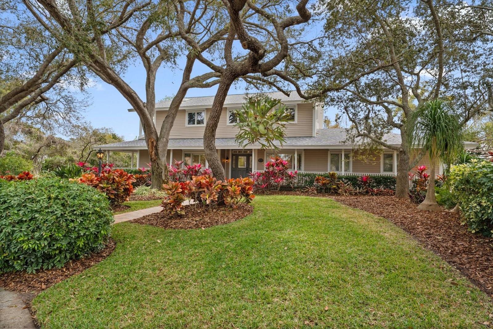 Nestled on a quiet cul-de-sac in the sought-after Weybridge Woods neighborhood, this stunning home on Curlew Creek offers privacy, elegance, and thoughtful updates throughout. Its striking curb appeal is enhanced by mature trees and professional landscaping, setting the tone for the refined lifestyle inside. The newly updated downstairs features a new wrap-around deck, fresh flooring and paint, two dedicated home offices, and a chef’s dream white kitchen equipped with a Viking gas range, new 5 foot stainless hood, Wolf double ovens, a walk-in pantry, a huge center island with prep sink, and a waterfall-edge breakfast bar. The kitchen flows seamlessly into a spacious family room with custom built-ins, a fireplace, and access to a massive custom cedar-lined wine cellar perfect for entertaining. The formal dining room, framed by walls of floor-to-ceiling windows, overlooks the enclosed pool and serene backyard. Outdoors, multiple venues await, including a covered deck with ceiling fans, a firepit, fountain and tranquil creek views. The luxurious downstairs primary suite boasts a walk-in closet with custom built-ins, dual-sink vanity, jetted tub, walk-in shower, and skylights that fill the space with natural light. Upstairs, additional bedrooms are thoughtfully designed with custom closets, plantation shutters, and a renovated hall bath, including a Jack-and-Jill layout for two bedrooms. Other highlights include a mudroom/laundry off the garage, extra RV parking, a garden shed, and move-in ready upgrades throughout. Just a short golf cart ride to downtown Dunedin and minutes to beaches, the Pinellas Trail, shopping, and dining, this home is Florida living at its finest.