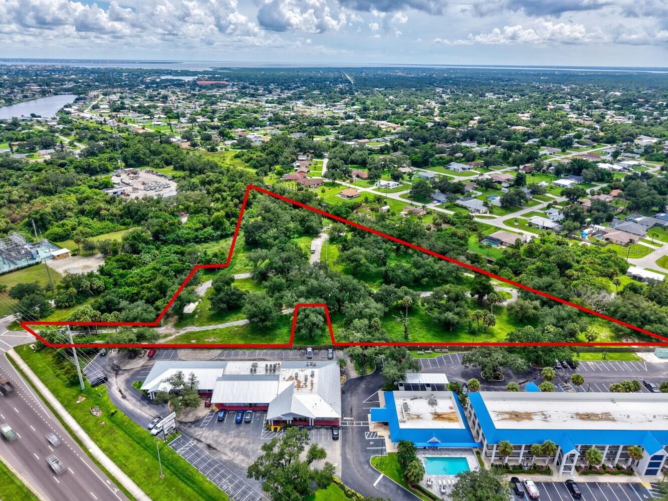 Located directly on the highly traveled Tamiami Trail (U.S. 41) in Port Charlotte, this property presents a rare opportunity for builders, developers, and investors to acquire prime commercial land in one of Southwest Florida’s fastest-growing corridors. Zoned CG (Commercial General), the site allows for a wide range of uses including retail, office, medical, restaurant, and mixed-use development. Offering full access from both directions of U.S. 41, the property provides exceptional visibility and accessibility for businesses seeking to capture strong local and commuter traffic.

Beautiful mature oak trees enhance the property’s character and curb appeal, while a scenic canal along the rear boundary creates a natural buffer and added sense of openness rarely found on commercial sites. With public water and sewer available adjacent to the property and no wetlands, the site is well-positioned for future development. Located near the Murdock Town Center, the property benefits from close proximity to one of Port Charlotte’s most active retail, medical, and commercial hubs.

As one of the few remaining large commercial acreage opportunities along U.S. 41 in Port Charlotte, the property offers multiple development possibilities in a corridor experiencing continued residential and commercial growth. Combined with strong traffic counts, flexible CG zoning, and limited availability of commercial land in the area, this is an exceptional Tamiami Trail development site and a premier Port Charlotte commercial investment opportunity.