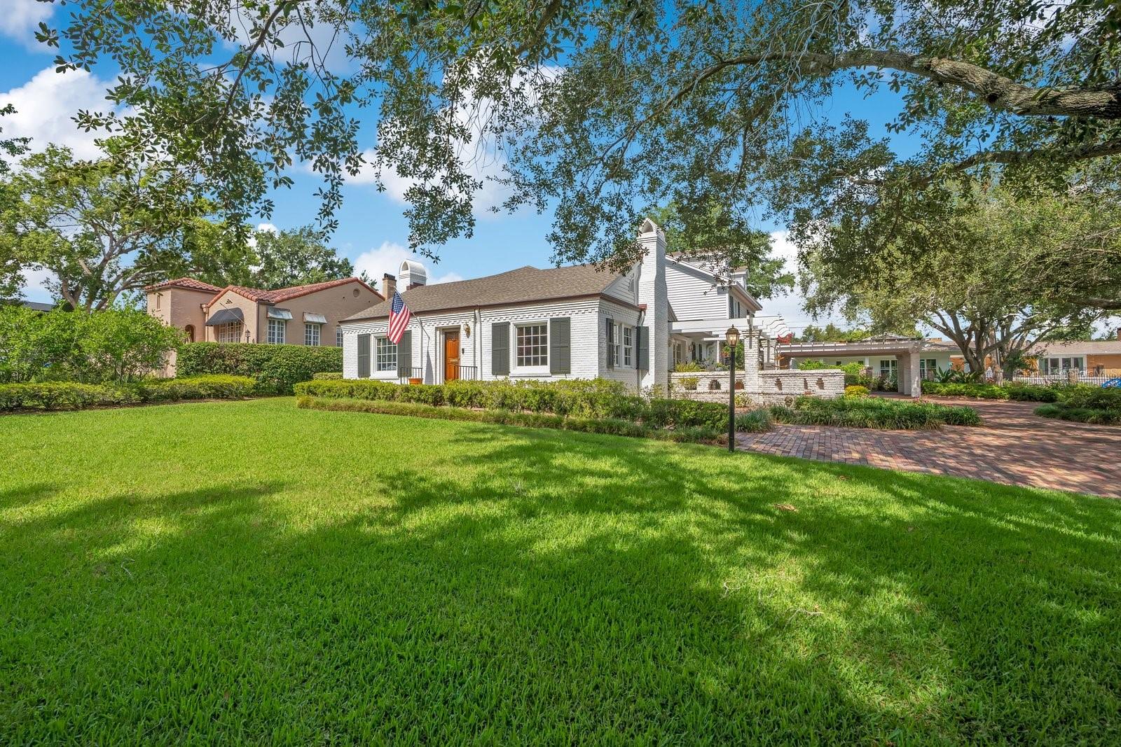 Iconic 1940s Brick Estate Near Lake Hollingsworth.
Situated on a spacious corner lot of nearly three-quarters of an acre, this classic 1940 brick home perfectly blends historic character with modern updates. Located just steps from Lake Hollingsworth, the property offers beautiful water views and easy access to the lake's popular walking path.
The spacious interior features a thoughtful layout with multiple ground-floor primary suites, classic trim work, and original brick and hardwood flooring. The heart of the home is a large family room featuring rare, reclaimed American Chestnut wood paneling. Living spaces include a formal living room with a natural gas fireplace, an elegant dining room, a sunlit breakfast nook, and a private den/home office.
While preserving its timeless cottage charm, the home is fully modernized with key infrastructure upgrades, including an updated electrical system, dual tankless gas water heaters, a whole-house generator, and a security system.
Enjoy the best of Lakeland living with scenic lake views, close proximity to downtown shopping and dining, and quick access to the Parkway for an easy commute to Tampa or Orlando.