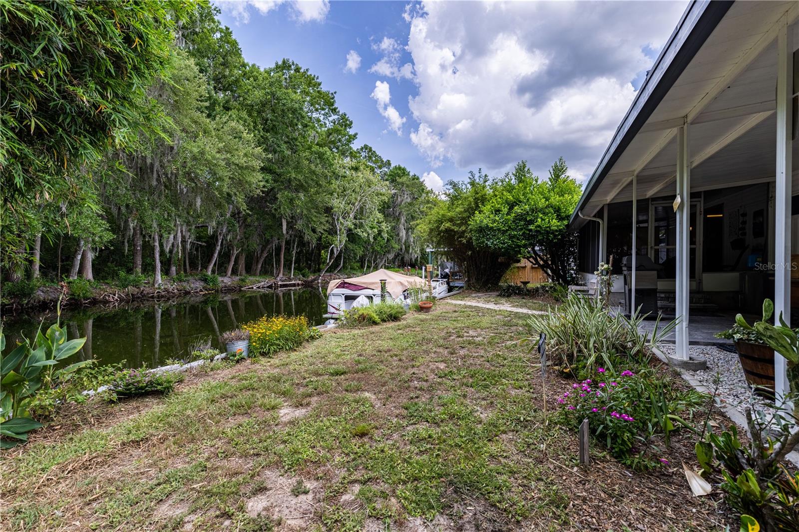 Welcome Home to the Best Location in the Tavares Les Chateau Villa MHP! This rare canal-front gem sits on an impressive 90 feet of water frontage along the Dora Canal, your private gateway out to Lake Dora, Lake Eustis and the entire Harris Chain of Lakes. Located in a small, tucked-away waterfront community in Tavares, this home is move in ready and is being offered partially furnished and includes a 2005 Bentley Pontoon boat. The home features two bedrooms, two bathrooms and a sizable carport for covered parking. The shed stays with the home for additional storage. You will be impressed when you step inside and notice the updates that have been made through the years. Luxury vinyl flooring flows throughout the living spaces, offering both easy maintenance and a fresh, updated feel. The kitchen has been updated with granite countertops and offers lots of storage and the appliances stay. Both bathrooms have also received thoughtful updates. With the best lot in the entire community, you're not just buying a home, you're securing a front-row seat to Central Florida's waterfront lifestyle. Spend your mornings with coffee overlooking the canal from your screened in back porch. Come see why this is truly the best spot this neighborhood has to offer. All information recorded in the MLS is intended to be accurate however, it should be independently verified by buyer and their agent. Check out the Virtual Tour!