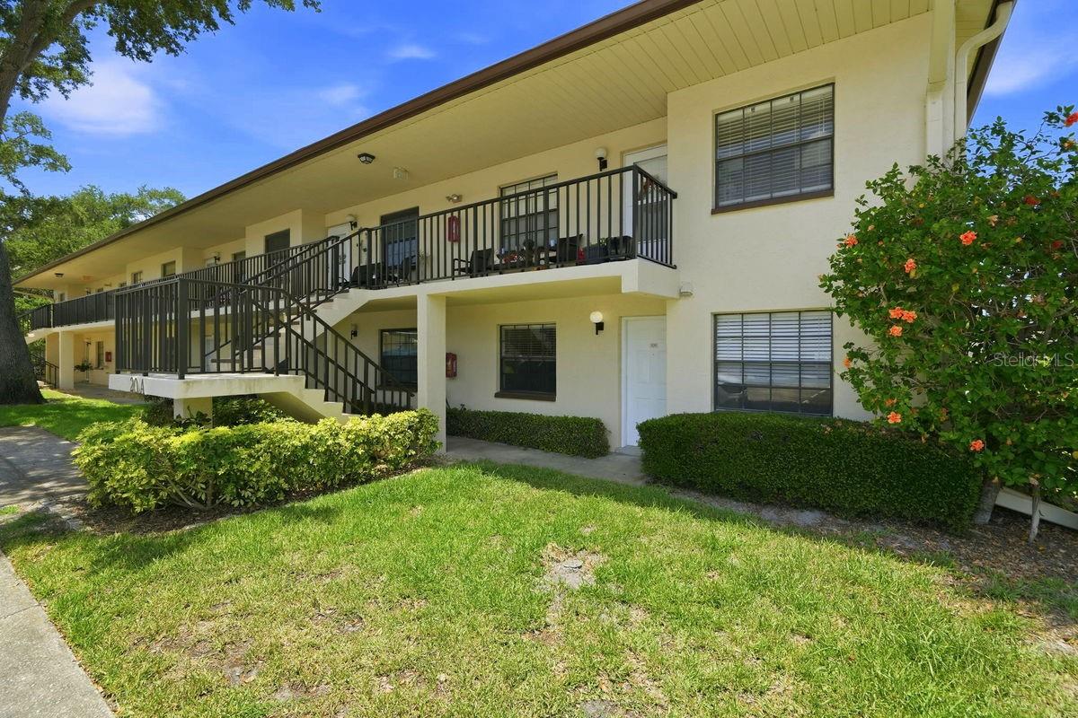 Virtually Staged. This RARE ground floor corner 2BR/2BA condo is ideally located in the sought-after community of Winding Creek. It sits on high ground in a NON flood zone and is centrally located with access roads leading to all parts of the county. The unit has a bright, spacious, split bedroom plan that includes the following: welcoming foyer, spacious great room, eat-in kitchen, master bedroom with private bath & walk-in closet, office or guest bedroom, 2nd full bath, utility closet with full size washer & dryer, bonus area, PLUS a rear paved patio perfect for your morning coffee & evening glass of wine. As an end unit, additional windows allow natural light to shine in the great room. Updates include, MASTER BATH: vanity with dual sinks - stone counters and soft close drawers & doors, faucets, mirror, light fixture, toilet, showerhead & custom tiled walk-in shower, HALL BATH: vanity with stone counters, faucet, mirror, light fixture, showerhead, and custom tiled tub, INTERIOR: luxury vinyl flooring, new water heater (2026), and AC system (2021), EXTERIOR: newer roof (2021), and painted parking spots. Unit includes an assigned parking spot footsteps from the front door as well as ample guest parking. This building is non-age restricted, pet friendly, and adjacent to the pool & clubhouse. Winding Creek is a well maintained community with mature plants-shrubs-palms-majestic trees & green lawns. Amenities include: active clubhouse with kitchen - social area - meeting & game rooms, heated pool & spa, tennis/pickleball court, and BBQ picnic area. It is conveniently located a short drive from major shopping hubs, Countryside Mall, Historic Downtown Dunedin, Eclectic Safety Harbor, and Award Winning Clearwater Beach. Enjoy Florida living at its finest with countless activities nearby: beaches, water sports, boating, parks, casual & fine dining, trendy bars, micro-breweries, cafes, festivals, concerts, art shows, theaters, spring training baseball, championship golf & more. This is a MUST SEE for buyers seeking maintenance free living in a desirable community.