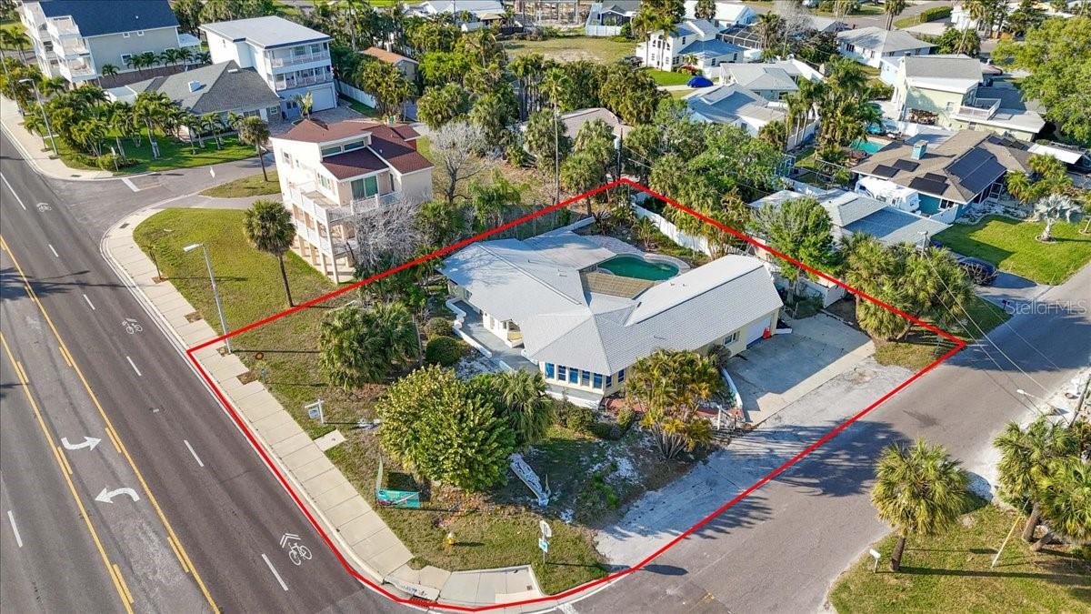 This .30-acre (13,068 sqft) corner property, situated at the intersection of Gulf Boulevard and 160th Avenue in Redington Beach, presents two distinct investment opportunities. The first involves restoring the property to its original grandeur as a unique, spectacular 1940s home through rebuilding and remodeling. The original custom-designed home featured a wraparound design with a distinctive hexagon-shaped living room. The property's pool is fully functional, and city approval is in place to remodel the home in its current state. Given the area's allowance for short-term vacation rentals, the property could be used for that purpose, as it has 4 parking spaces. Furthermore, the property includes a 16x17 studio attached to the main home with a private entrance. Alternatively, developers may consider removing the existing structure and constructing two new homes, which could be the soundest investment given the newly permitted height allowance of 35 feet above the base flood elevation (BFE). The addition of rooftop decking would provide stunning views of the Gulf sunsets.