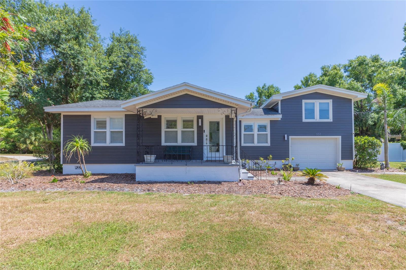 This amazing versatile home located in the heart of Seminole Heights on a corner double lot has plenty of space and a layout to get lost inside and out. So close to riverfront parks, you can feel the breeze on your front porch. The welcoming artistic hardwood floors give classic bungalow vibes and contemporary open floor plan in the back has the perfect flow to entertain anytime of the year! Open kitchen has stainless steel appliances, shaker cabinets and granite countertops for all your foodie needs and company can join you at the eat in kitchen bar while you cook. Great open space with saltwater pool views from the dining, kitchen and large living room. Dual French doors brings the outside in, and with built in shades and hurricane impact rated windows help keep things cool. Need more space? Take your chef skills to the outdoor kitchen while guests lounge under the pergola, by the firepit, screened in lanai or in the pool. This 4 bedroom 3 bath home has a split level design with 2 bedrooms on the main floor on opposite ends of the house, with one bedroom having its own private access to the backyard and ensuite bath. Upstairs the large primary bedroom has a great Florida view of the backyard. An additional centrally located loft with bath provides extra space for quiet times or privacy if you work for home and need some respite. Garage with built in cabinets to accommodate any artistic or hobby ventures. Florida friendly landscaping and privacy fence provides an oasis in the heart of the city. Large side gate and yard to where you can bring your boat, RV or any other toys. So much space to make this home yours! Siding replaced in 2024, AC 2023, new salt cell for pool 2025. Wonderfully maintained home and move in ready!