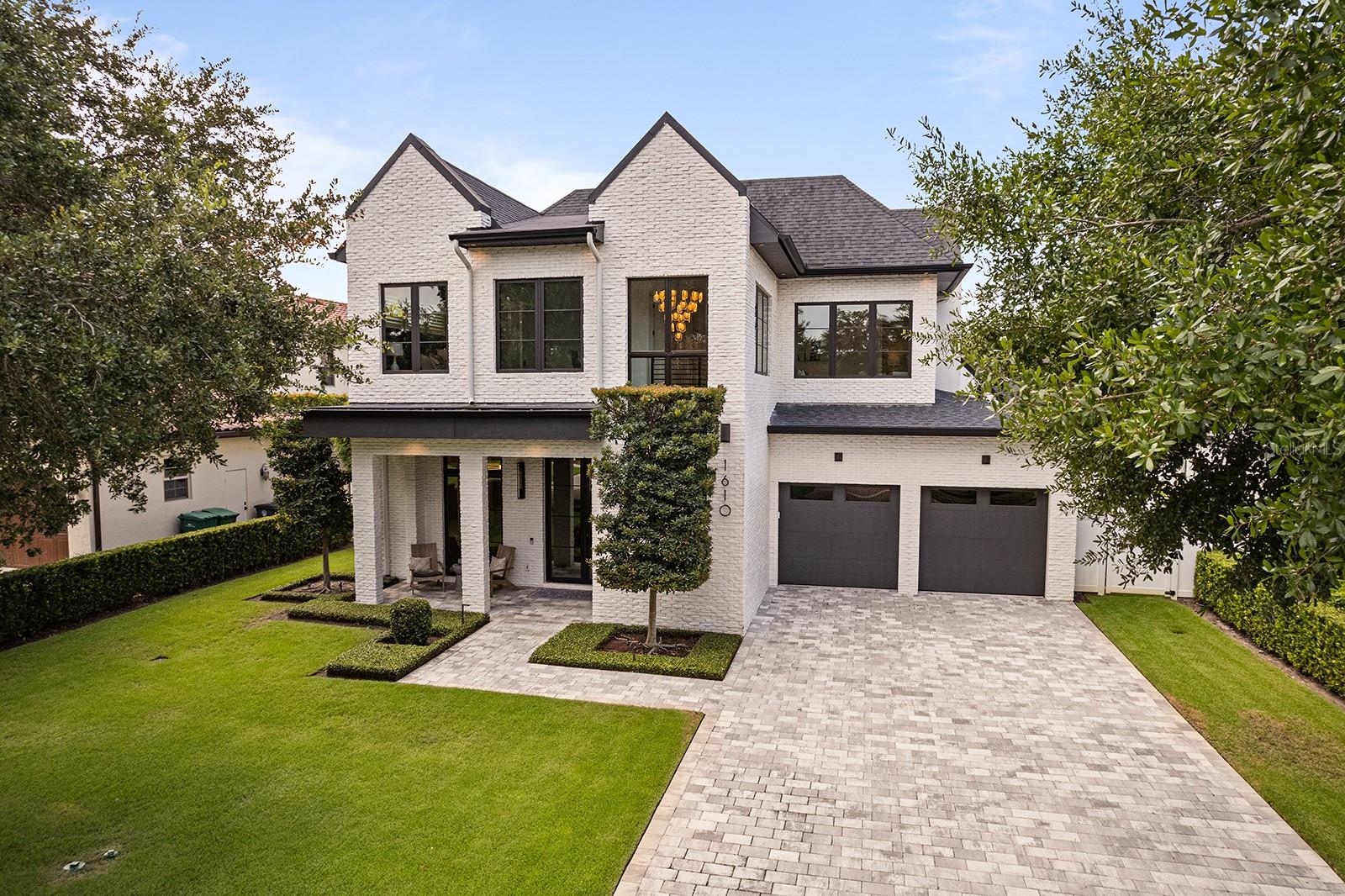 This stunning modern farmhouse residence, custom-built in 2021 with meticulous attention to detail offers a bright open living design, luxurious finishes, and an ideal floor plan for everyday living and grand-scale entertaining. This home includes five en-suite bedrooms (owner’s suite and potential guest suite on first level) and three bedrooms, plus lounge/flex area upstairs… or a fourth bedroom, office plus lounge/flex area and five full baths plus 2 1/2 baths. The entire property has been maintained in better than new condition featuring gorgeous light wood flooring that transcends the entire home with elegant herringbone design throughout the entry foyer. The open-concept layout is flooded with natural light thanks to walls of sliding glass doors, including a disappearing wall that seamlessly connects the indoor living spaces with the incredible outdoor transitional lanai that is really cool to enjoy outdoor living and has its mini-split air conditioning system. The chef’s kitchen is a showstopper, featuring top-of-the-line appliances, a large island with seating, integrated refrigeration, wine refrigerator and a hidden butler’s pantry with an additional refrigerator—all open to the spacious dining and living areas. The living room showcases floor-to-ceiling windows, a striking fireplace with built-ins, and tranquil views of the beautifully landscaped yard and pool. The private first-floor primary suite features direct access to the backyard and a spa-like bath with a soaking tub and oversized glass shower. A second first-floor bedroom suite, used as an office, provides versatility for guests or multi-generational living. Upstairs, there is a spacious lounge area and three additional bedrooms with en suites, all featuring walk-in closets. The outdoor lanai offers a summer kitchen, gas fireplace and remote-controlled screens under soaring wood ceilings, creating a year-round gathering space. Complemented by a resort-style pool and heated spa surrounded by lush tropical landscaping and manicured bamboo for total privacy. Additional highlights include a drop off/mudroom zone off the two-car garage, a generous laundry room, and an ideal location on a charming brick street just minutes from Park Avenue’s shops and restaurants. Zoned for top-rated public schools and near elite private schools, with easy access to Phelps Park, YMCA, ICC, WPRC and Park Avenue—this exceptional home checks every box!