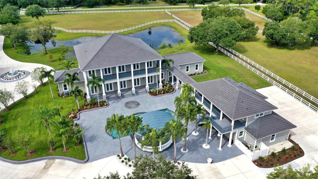 There aren't many places where you can find a tranquil "country" setting complete with horses and a big blue sky less than 20 miles from area beaches (or about 40 minutes) for when you must get some sand between your toes.  This just happens to be one. 
Sacrifice nothing.  You can have it all. This 9+ acre estate has just been outdone with new tile roofs on all buildings, foam insulation in all attics for energy efficiency, hurricane impact windows to scare away the storms (okay, to resist winds up to 150 mph - but the other sounds much more fun), 4 new, highly efficient inverted A/C systems, beautiful new wood flooring, wood cabinetry, quartz countertops, LED lighting, walk-in closets with wood shelving, new appliances, security monitoring system with live feed, recording facility and off-site monitoring - you shouldn't need it, but if you have certain security requirements, they're already here.
You want to entertain? Media package includes TV, WiFi, Full home Audio, Lighting and other Smart Tec items or Fly your friends in.  Sarasota/Bradenton International is just a short drive away and once your guests arrive they will be pleased to explore over 2700 square feet of stables and (hopefully) the five horses you choose to live in them.  Never a dull moment with 5 fenced and gated paddocks with a horse training circle corral.  During the day you can live out your "cowboy dreams" and in the evening play by the pool and enjoy live music (hire your favorite band - there's plenty of room in the cabana) and revel in the tranquil pastoral setting.  You've earned it.  Your guests will appreciate the separate guest house as they retire late into the night.
This Panther Ridge Estate is just minutes from prestigious golf courses, shopping, restaurants, and some of the most beautiful beaches in the world.  If you are ready to make a move full-time you'll find Florida is one of the rare states with no state income tax and relatively low property taxes. Schedule your private showing today. Room Feature: Linen Closet In Bath (Interior In-Law Suite).
