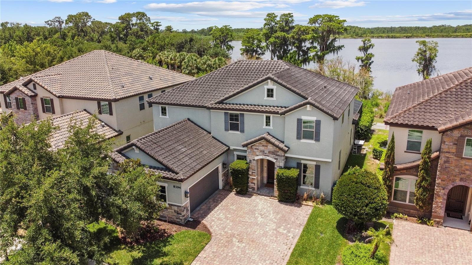 FREE DISNEY FIREWORKS show nightly with purchase! Perfectly positioned in the highly sought-after community of Windermere Trails, this beautifully updated home overlooks picturesque Lake Reams and offers the kind of lifestyle that makes people fall in love with Central Florida. From the stately elevation featuring stone accents, a tile roof, paver driveway, and elegant color palette, you'll immediately notice the attention to detail. Inside, exquisite marble floors, crown moulding, upgraded lighting, and a dramatic staircase create a timeless first impression. The recently renovated kitchen is truly the heart of the home. Crisp white cabinetry adorned with traditional millwork, glass display cabinets, brushed gold pendant lighting, and an oversized island blend beauty and function effortlessly. Quartzite, granite, and other fine stone finishes have been thoughtfully incorporated throughout, creating a refined yet comfortable atmosphere. Designed for both entertaining and everyday living, the home features a formal dining room, spacious eat-in kitchen, and multiple gathering spaces overlooking the pool and Lake Reams beyond. Two sets of French doors open to the covered lanai, seamlessly connecting indoor and outdoor living. With five bedrooms, four bathrooms, and a dedicated office on the main level, there is flexibility for growing families, remote work, guests, or multigenerational living. Wake up to water views and enjoy evening sunsets from your private backyard retreat featuring a sparkling pool and covered lanai. The upstairs loft also offers the same beautiful view! Residents of Windermere Trails enjoy miles of walking trails, a community pool, playground, picnic pavilion, and some of the area's most desirable schools. Located just minutes from shopping, dining, and approximately 10 minutes from Disney, this location offers convenience without sacrificing the charm and character that make Windermere so special.