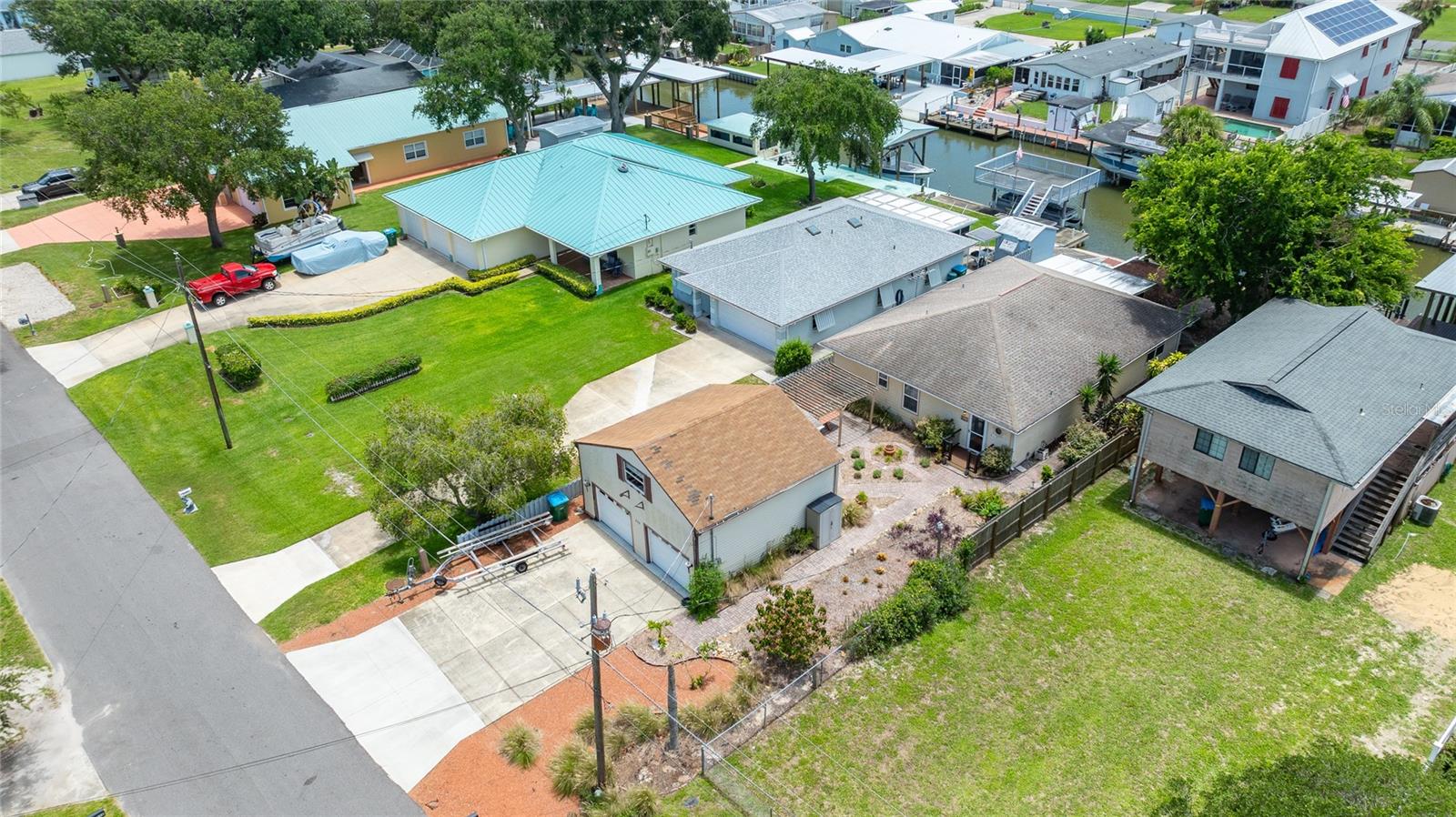 Attention all boaters and nature lovers! This canal front fishermans paradise is located just off the Intracoastal waterway. Enjoy all the natural beauty that SE Volusia waterfront living has to offer. This home features an open floor plan with the kitchen and bar overlooking the dining room and spacious living room. The bar surrounding the kitchen is great for entertaining. The kitchen features full appliances and lots of counter and cabinet space. Walk out the back door off of the kitchen to a screened enclosure FL room which overlooks the canal and boat dock. This home has 3 bedrooms, one is being used as a TV/ bonus room but has a closet. The large master bedroom has a bath with a double sink vanity, shower enclosure and large walk in closet. There is a detached 2 car garage with a 500 sq ft loft workshop. The loft space could easily be converted to additional living space.The garage also has a first floor smaller workshop. With both workshops there is plenty of room for storage. The house AC system new in 2024. The waterfront features include a private boat ramp with wench, a covered boat slip with electric strap lift and an enclosed storage room for all of your boat and fishing gear. There is a private boat ramp to launch your watercraft. Come sit on the screened enclosure and watch the manatees swim by or take your boat out to the world class fishing grounds, all just outside your backdoor! Step out into the back yard to watch the weekly rocket launches at Canaveral. This location is also a short drive to the beach, 30 minutes to Kennedy Space center, 45 minutes to the Orlando airport and an hour to the Orlando attractions. The furniture and pontoon boat are negotiable.