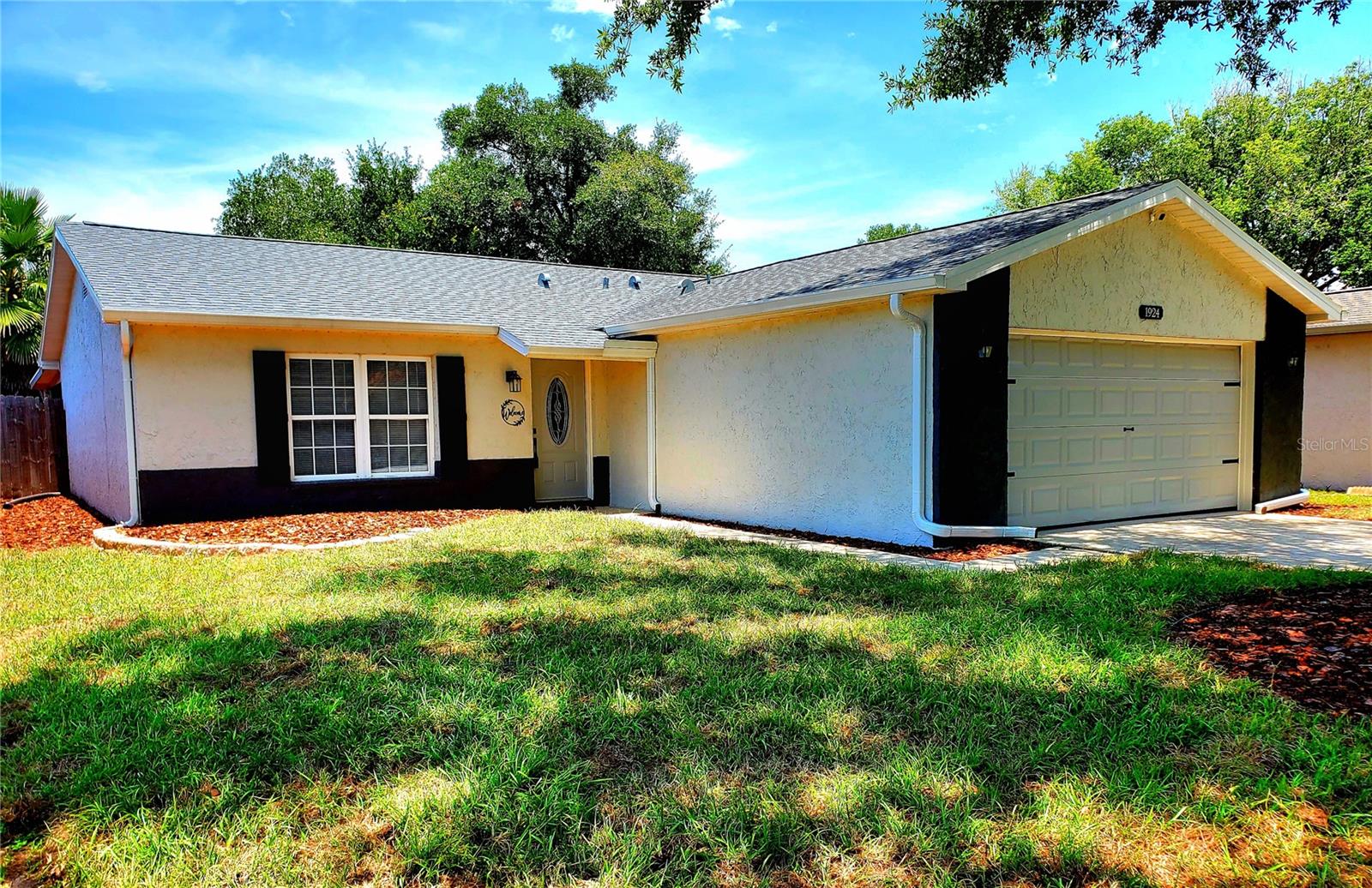 **SUPER STARTER HOME!!** What a fantastic house for the price! From the moment you arrive, you’ll be wowed by the striking curb appeal. The freshly painted exterior is complemented by a newer roof and landscaping, with a 30-year dimensional shingle roof installed in 2024 and a transferable 10-year warranty. Inside, the spacious, open floor plan is just as impressive, starting with a leaded glass front door. This move-in ready home has been updated throughout, featuring a tiled great room with a lighted ceiling fan and a large front window that fills the space with natural light. The eat-in kitchen offers a cozy dinette, updated soft-close cabinetry, stainless steel appliances, recessed lighting, and tile countertops with backsplash. Down the hall are three bedrooms, all with lighted ceiling fans and new carpet. The primary ensuite boasts an updated bathroom with a walk-in shower and new hardware, while the guest bath offers resort-style features. Step through the back sliding glass door to a screened lanai with tile floors—perfect for relaxing or entertaining. The modest fenced backyard has fresh mulch and is easy to maintain. With a new A/C installed in 2022 and a prime location near trendy restaurants, shopping, AMC Woodlands Movies, and just minutes from Tampa, the airport, or the beach, this home truly has it all—don’t miss it!  (house has never had any issues with flooding in 20 years owner has owned it)