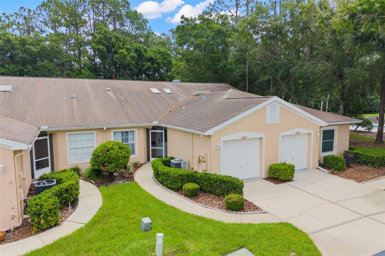 Welcome home to this beautifully maintained 2-bedroom, 2-bath with 1 car garage villa featuring soaring high-volume ceilings, abundant natural light, and peaceful conservation views. Ideally situated just steps from the community pool, this quiet yet convenient location offers the best of Florida living. As you enter, you'll find the spacious guest bedroom just off the foyer, complete with a generously sized wall closet and full bath; The open-concept living, dining, and kitchen areas feature durable laminate flooring throughout, creating a seamless and airy feel. The kitchen is designed to impress with granite countertops, white shaker cabinetry, and a stunning tile backsplash that extends all the way to the soaring ceiling. Skylights fill the space with natural light, while a bonus island with breakfast bar seating and an additional breakfast bar overlooking the dining and living areas provide plenty of room for entertaining. Additional cabinetry, shelving, and large storage closets offer exceptional organization throughout the home. The guest bathroom is conveniently located off the main living area and features a tub/shower combination, updated vanity, and nearby linen closet for extra storage. Retreat to the privately situated primary suite at the rear of the villa, where sliding glass doors provide direct access to the screened lanai. The spacious en-suite bath includes a soaking tub, separate step-in shower, and updated vanity, creating a relaxing spa-like atmosphere. Enjoy morning coffee or evening sunsets from the screened rear porch overlooking tranquil conservation views. Additional highlights include a full-size in-unit washer and dryer, ample storage throughout, and a one-car garage perfect for parking or additional storage needs. Offered furnished or unfurnished, this move-in-ready villa combines comfort, style, and convenience in an unbeatable Ridgemoor location. HOA Includes Basic Cable, Community Pool, Escrow reserves, Exterior Maintenance, Roof and Ground Maintanence, as well as Trash! AC is 2021 Community offers close location to shopping, dining, recreation - ameneties include a community pool as well as tennis courts, basketball courts and a playground! Nearby enjoy John Chestnut park offering boat ramp, walking trails, picnic pavilions, playgrounds and so much more!