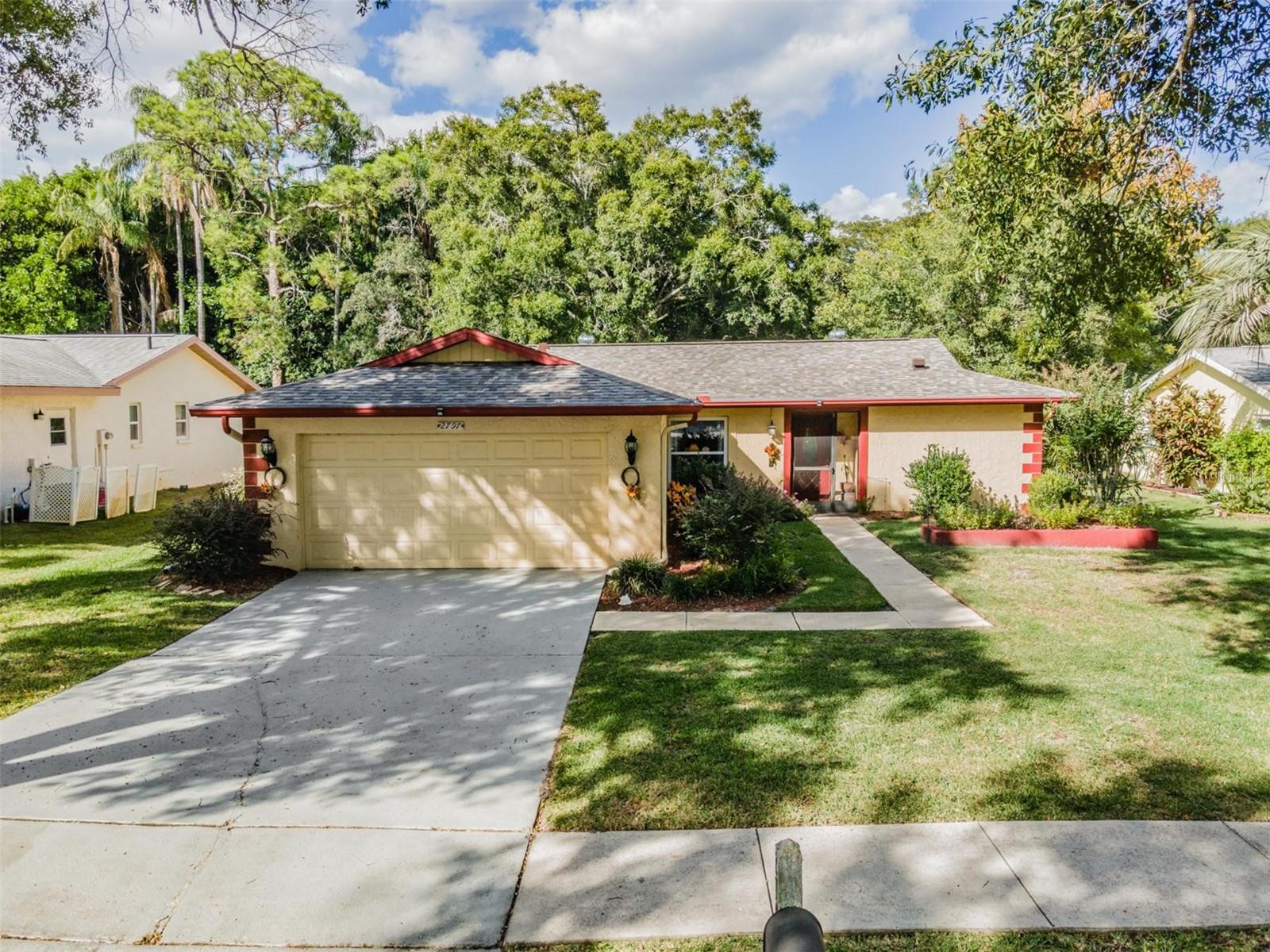 Welcome to the highly desirable 55+ community of Highland Lakes!?This lovely home boasts 2 bedrooms, 2 full baths, and a two-car garage, making it the perfect choice for a new homeowner. As soon as you step inside, you'll notice the open floor plan and cheerful color scheme that gives this home a warm and inviting feel. The updated kitchen features beautiful granite countertops, recessed lighting, light gray tile backsplash which complements gray cabinets, and stainless steal  appliances.  Every window is designed to withstand high impact.  The living area flows into a private Florida room that offers a stunning view of the wooded lot, creating an ideal space for entertaining, unwinding, or appreciating nature.  The master ensuite is very inviting with a walk-in closet, double vanities, and a large walk-in shower. Both bathrooms have been updated with new vanities and lovely granite countertops. Additional features include a  water softener, ceiling fans, and a new roof (installed in 2023).  Explore the Highland Lakes community and uncover its many amenities. Enjoy three executive nine-hole golf courses, a clubhouse featuring a heated Olympic-sized pool and spa, tennis, bocce, pickle ball, shuffleboard, and fitness classes. Connect with other residents by joining clubs or attending social events. You can also take a dip in the pool at the Lodge on Lake Tarpon and take a tour on one of the Pontoon Touring Boats. Seize the chance to transform this charming house into your dream home! – schedule your appointment today!
