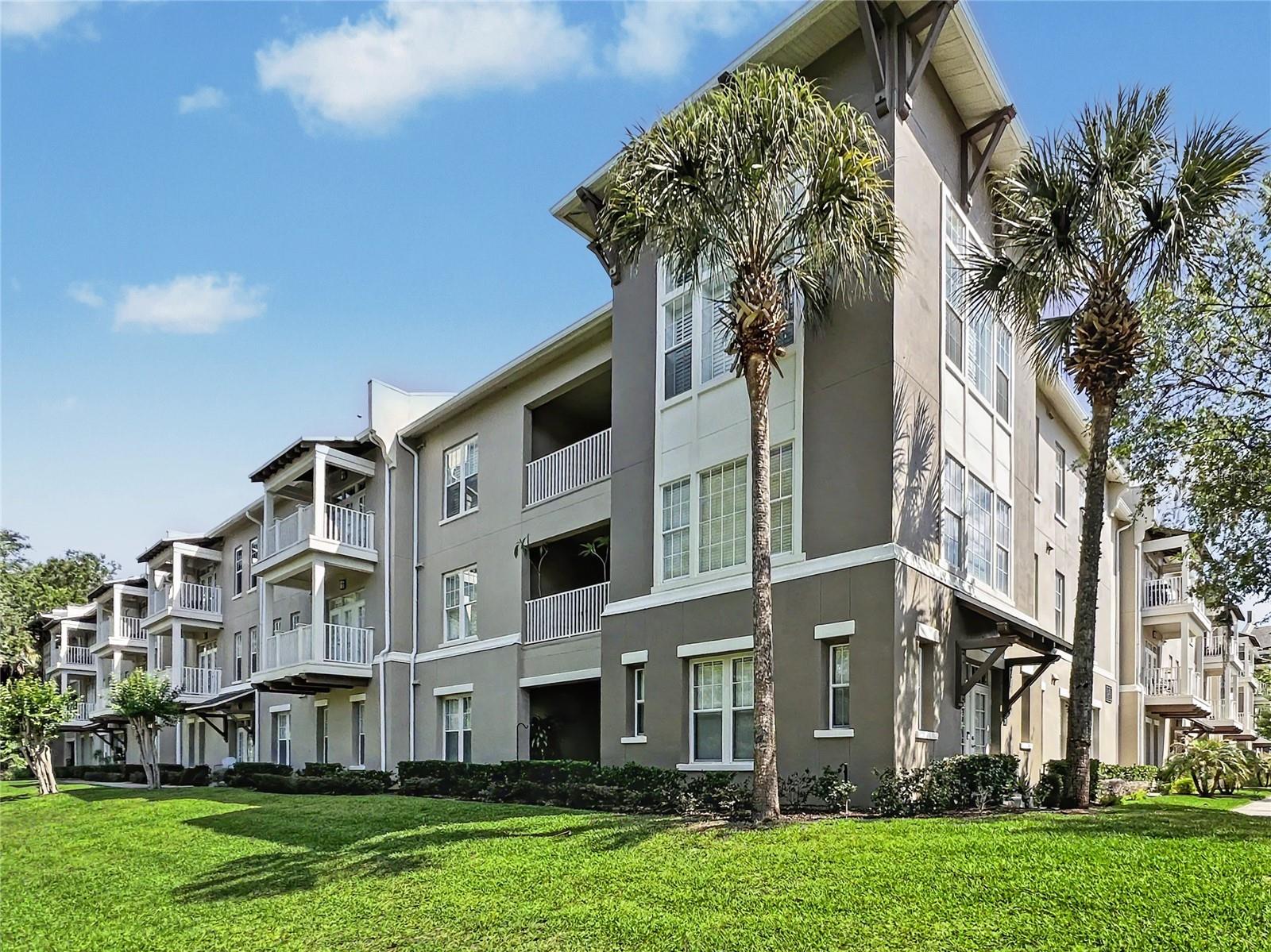 A RARE GEM! True 4 bedroom condos are rare to find in the exclusive Artisan Park neighborhood of Celebration, FL (the town built by Disney!) This one-story unit (all on floor floor!) boasts an open floor plan, with french doors that lead out to a patio and spacious grassy area that can be used as yard space for recreation and relaxation.  The lawn is maintained by the association.  Water, Trash, and Sewer utilities are also included in your condo dues. This unit backs to conservation, so you can enjoy tranquil forest views while sitting out. The building is located beside a lovely pond, where residents fish and take the scenic path toward the award-winning community clubhouse. These offer the best amenities is Celebration for Artisan Park residents, with the largest heated pool, fitness center, private restaurant, and more.  This condo is in an elevator building, making it easy to visit your neighbors.  You will enjoy a split floor plan, with two guest bedrooms in their own wing, closed off by a privacy door.  The primary bedroom is large and features window views of conservation, a massive closet, and luxurious primary bathroom with enclosed water closet.  Ample windows let in plenty of natural light, keeping your large kitchen space well lit and cozy. Kitchen features a breakfast nook space for additional seating, as well as granite counter tops and plentiful cabinetry.  Entering your home is simple with attached garage! There is also street parking as well for guests.  You are never far from Downtown Celebration, with it's famed shops and restaurants and community events and festivals that make this town a magical place to live.  The drive is mere minutes from Disney Parks and roughly 20 minutes to Orlando International Airport.  Easy to show, call today! And don't miss our Video Tour!