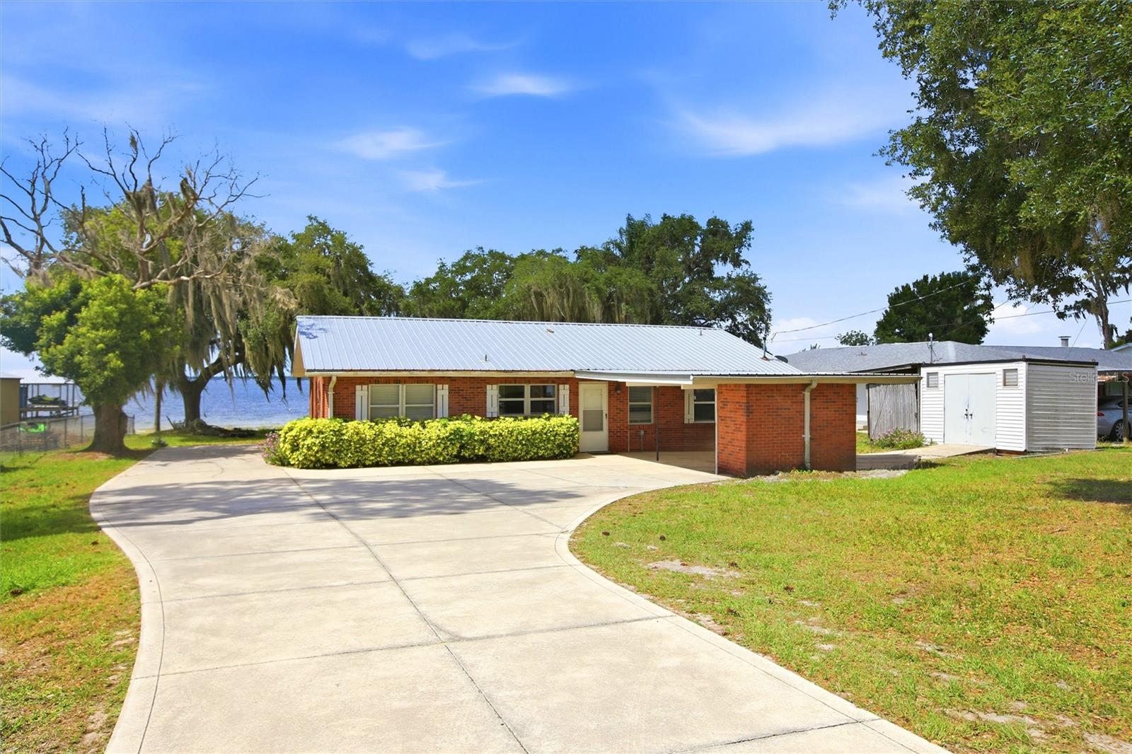 Lakefront Living on Beautiful Lake June – Your Florida Waterfront Dream Awaits! Welcome to this 4/2 home in Lake Placid,
FL, where breathtaking lake views, timeless charm, and endless waterfront adventures come together on one of Highlands
County's most sought-after lakes. Perfectly positioned on the sparkling shores of Lake June-in-Winter, this inviting
lakefront retreat offers the ideal blend of comfort, character, and recreation. From the moment you arrive, you'll
appreciate the classic brick exterior, durable metal roof, covered carport, and mature oak trees draped in Spanish moss
that frame the property like a postcard. Inside, the spacious open-concept living area is designed to showcase the
spectacular waterfront. Warm tongue-and-groove wood ceilings create a cozy, lodge-inspired atmosphere, while expansive
windows flood the home with natural light and capture panoramic lake views from nearly every angle. The updated kitchen
features abundant cabinetry, generous counter space, and flows seamlessly into the dining and living areas—perfect for
entertaining family and friends after a day on the water. Wake up each morning to peaceful sunrise views over the lake,
sip your coffee from the screened porch, or spend your afternoons fishing, boating, kayaking, paddleboarding, or simply
relaxing beneath the shade of majestic oak trees. A private dock provides direct access to Lake June, one of Central
Florida's premier recreational lakes known for exceptional bass fishing, boating, and year-round enjoyment. Whether
you're searching for a full-time waterfront residence, a vacation getaway, or an investment opportunity, this property
offers the lifestyle buyers dream about. Imagine hosting family gatherings, enjoying evenings by the water, and creating
memories that will last for generations. Conveniently located just minutes from charming downtown Lake Placid, you'll
enjoy easy access to local restaurants, golf courses, shopping, medical facilities, and all the small-town charm that has
made Lake Placid one of Florida's hidden gems.