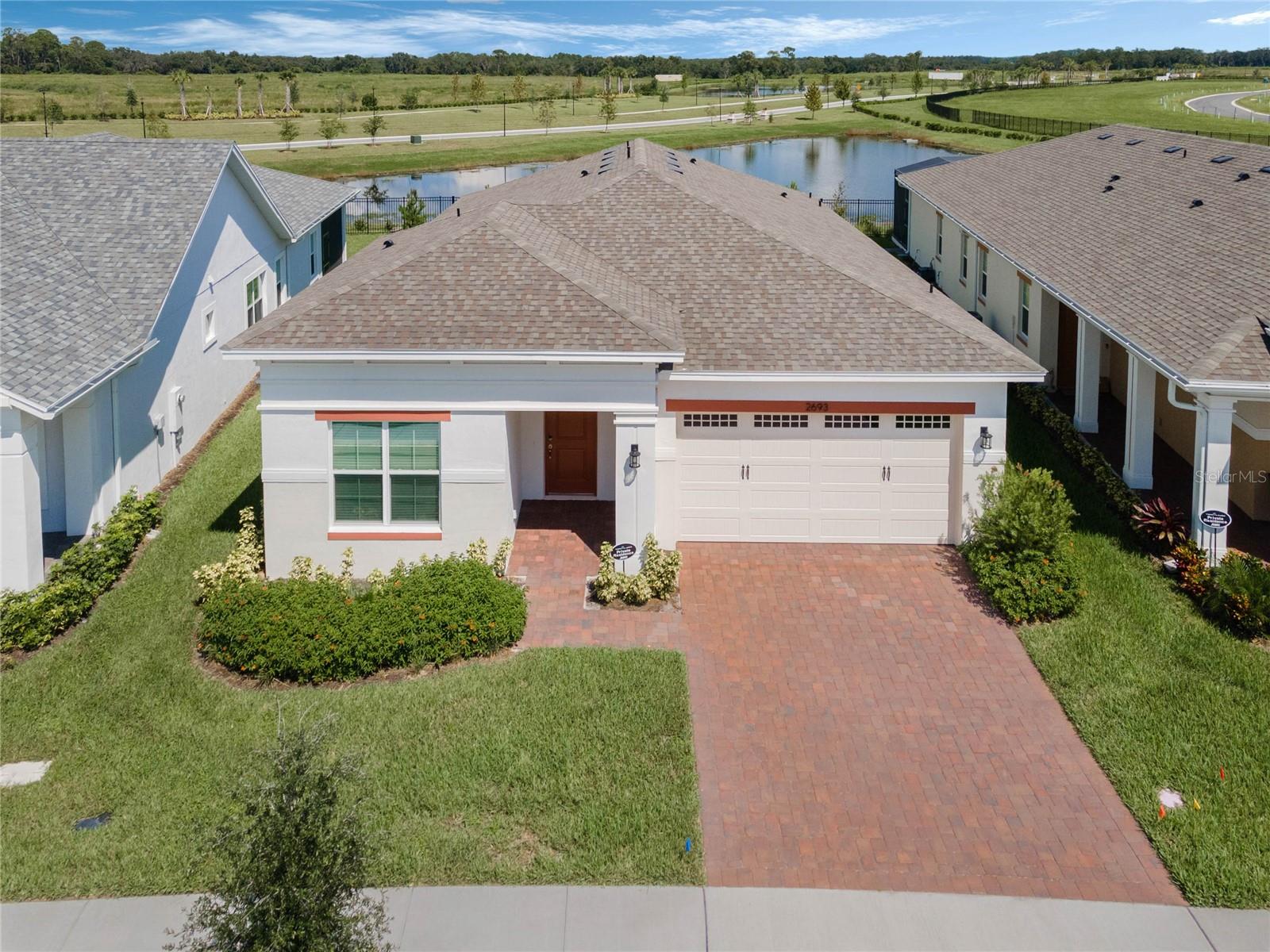 BETTER THAN NEW! This 2023 MODEL HOME is situated in the popular 55+ community of TWIN LAKES in St Cloud. This one-story home features a huge backyard with water views and tons of UPGRADES ($35 thousand in selections!). This nearly 2,000 sq ft home features 4 bedrooms, 3 bathrooms, and a well-appointed kitchen with island, stylish chrome vent, gas cooktop, and an upgraded oven/microwave wall combo. Retreat to the private master bedroom and en-suite bath & large walkin closet. Enjoy the open concept floor plan that features upgraded woodstyle tile throughout the living areas, custom cabinetry, fresh neutral paint, high ceilings with tall windows for tons of natural light, large laundry room with sink, & morning sunrises over the backyard's beautiful water view! Step out through the sliders to a spacious,  screened lanai with the upgraded privacy 1/2 wall (pre-plumbed for an outdoor kitchen!). In addition, enjoy award winning amenities including a zero entry pool, a lap pool, fitness center, access to Lake Live Oak, outdoor kitchens, basketball courts, pickleball courts and so much more! Plus, the dedicated landscaping crew keeps the community and homeowners lawns lush and well cared for all year long! Great location with easy access to the airport, 40 minutes to the beach, and 20 minutes to Lake Nona and Medical City. Turn the key and start your maintenance free life at Twin Lakes today!