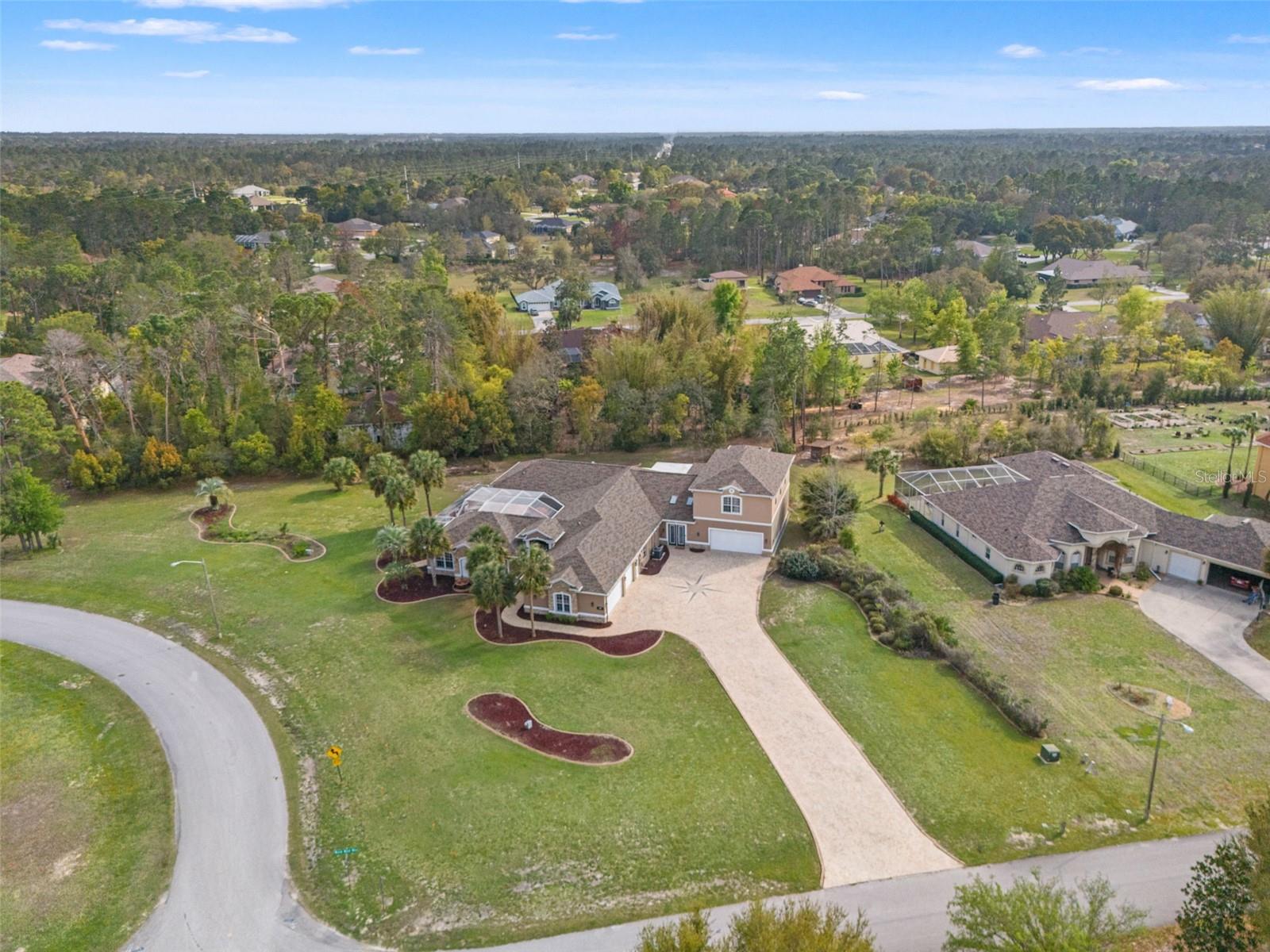 This fully custom 5,536 sq ft two story estate sits on a premium corner lot in the heart of Woodland Waters, offering a private guest suite, 6 car tandem garage, resort style saltwater pool, dedicated home theater, and an upstairs bar and game room that sets this property apart from anything else in the area. The HOA is just $14/ month with no minimum lease restrictions, giving the next owner complete flexibility from day one. From the moment you arrive, the grand entrance commands attention. A spacious six car tandem garage offers room for vehicles, storage, a home gym, or all of the above. Step inside and the grand foyer welcomes you with polished porcelain marble flooring flowing into the formal living and dining area. Soaring tray ceilings, including triple tray ceilings in select rooms, and crown molding throughout give the home an elevated custom feel at every turn. The open kitchen features solid wood cabinetry, stone countertops, a double oven, top of the line appliances, and a dedicated kitchen reverse osmosis system. The primary suite is on the main floor with dual walk-in closets, dual vanities, a large soaking tub, and a spa style shower. Four additional bedrooms are generously sized, and the dedicated home office opens directly to the covered lanai. The guest suite includes two bedrooms, one full bathroom, and a private entry, functioning as a fully separate living space ideal for extended family or multi-generational living. Step outside and the resort lifestyle comes into full view. The saltwater pool features a cascading waterfall, full screen enclosure, and beautifully laid poolside pavers. The outdoor kitchen is fully equipped with granite countertops, and the paved courtyard connects multiple rooms of the home for seamless indoor-outdoor flow that defines Florida living at its best. The custom home theater is fully soundproofed with a 150-inch projection screen. Upstairs, the game room and bar includes a second full kitchen, solid wood cabinetry, granite counters, custom lighting, a retractable 150-inch UHD projection screen, and a private balcony overlooking the 1.49 acre property below. Every major system has been updated. New roof in 2025. Three A/C units installed in 2018, 2021, and 2024 with UV filtration. Both water heaters are under 18 months old. The home features two septic tanks, a new whole home water treatment system, a water softener, and a walk in Fort Knox safe. Plantation shutters and luxury vinyl flooring run throughout. Located 3 miles from Weeki Wachee Springs, 8 miles from Bayport Gulf access, and one hour from Tampa and Clearwater beaches. A property this complete, this well maintained, and this thoughtfully built does not come along often.