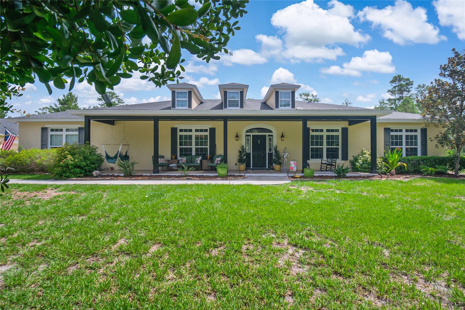 Rarely does 5 acres, 7 garage spaces, and resort-style living come wrapped inside a guard-gated community with country luxury at its finest! Beyond the manned entrance of Seminole Woods, a winding driveway meanders through the trees to reveal this exceptional 5-bedroom, 3.5-bath estate, where a welcoming front porch invites you to slow down and stay awhile. Step inside and be drawn straight to the true heart of the home: a gourmet kitchen designed for the entertainer. Custom 42" cabinetry provides abundant storage, gleaming granite countertops stretch across generous workspace, and the oversized center island with prep sink anchors it all.  Perfect for meal prep while guests gather around the breakfast bar. Double convection ovens make holiday feasts and Sunday dinners effortless, while the casual dining space keeps everyday meals easy and connected. A butler's pantry links the kitchen to the formal dining room, and a formal living room adds an elegant space for entertainment. The first-floor owner's retreat is a private haven with French doors opening directly to the pool area and a spa-like bath featuring a garden tub and separate walk-in shower, joined by three additional bedrooms on the main level. A dedicated office makes working from your countryside retreat effortless, especially with hardwired high-speed internet throughout. Upstairs, a spacious bonus/game room and 5th bedroom/flex space with private half bath offering room for everyone. But it's the outdoor living that truly captures the heart of this property. The screened patio is an entertainer's dream, perfect for gathering around the outdoor fireplace on cool evenings, relax in the sitting area with your morning coffee, or host weekend cookouts overlooking the sparkling pool and bubbling hot tub. Beyond the patio, the grounds unfold like your own private retreat: little ones playing safely on the commercial-style fenced playground tucked among the trees, mornings gathering fresh eggs from the newly constructed chicken coop, and homegrown harvests from the fenced garden lined with fruit trees. Car collectors and hobbyists rejoice with 7 total garage spaces, 3-car attached and 4-car detached. Saddle up and enjoy miles of horseback riding trails, a private neighborhood water supply, and exclusive access to private spring fed Buck Lake with community boat ramp. Zoned for top rated Seminole County Schools and just minutes from everyday conveniences of this is the country life, perfected. Schedule your private tour today!