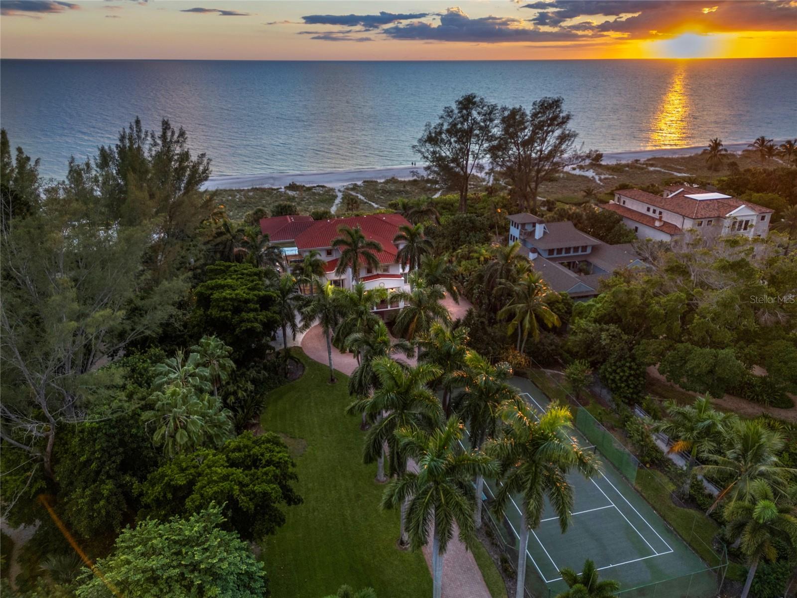 Experience the ultimate in beachfront living with this extraordinary 1.6-acre estate on Longboat Key, offering a rare 156 feet of direct frontage along the Gulf of Mexico. Embrace breathtaking water views and spectacular sunsets from every room and multiple balconies. The grand living room features soaring cathedral ceilings and dramatic walls of glass that frame the elevated pool deck with an infinity-edge pool, spa, and endless Gulf views beyond. A private, gated entrance and stately drive lead to a dual staircase entry, setting a tone of sophistication upon arrival. Inside, neutral finishes throughout the approximately 5,600 square feet of living space provide an easy canvas for personalization. Recent upgrades, including a fully modernized electrical system with enhanced lighting, a new HVAC system, an updated dining room, freshly painted interiors and exterior railings, refinished balconies, high-efficiency washers and dryers, and a state-of-the-art entertainment system ensure the home is up-to-date in both style and technology.  Garage space under the home can accommodate up to nine vehicles. This solidly built concrete block home did not sustain any damage from recent storms. Don’t miss this opportunity to own this exceptional beachfront retreat, offering breathtaking views, serene privacy, and refined luxury. The canal side property with boat lifts and dock directly across the street is also for sale offering the opportunity to own both properties beachside to bayside.
