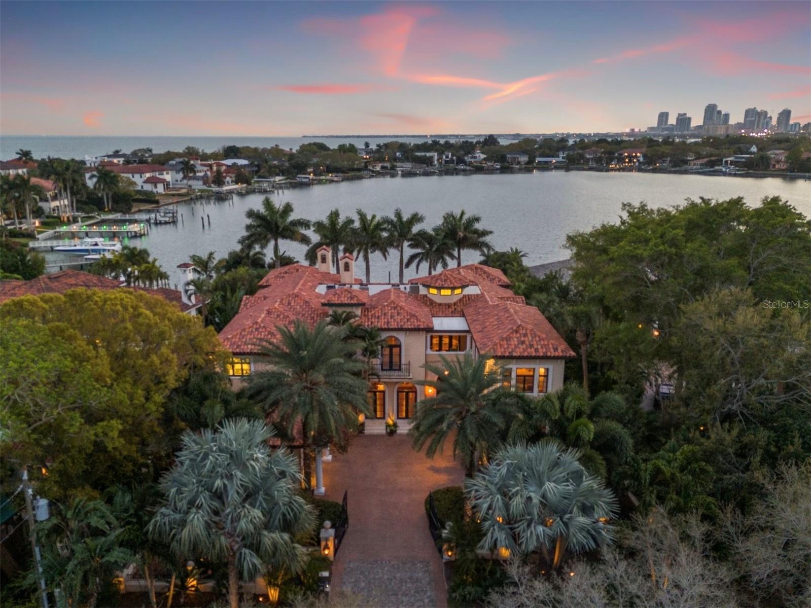 HIGH & DRY, no flooding from Helene or Milton. Two stories of full concrete block construction from slab to ceiling and a newer 2018 hurricane protected tile roof provide the pinnacle of protection and safety for this magnificent waterfront estate. Picture this: imagine driving through a majestic, gated entry, greeted by an avenue of towering palm trees leading to a Grand Mediterranean masterpiece that redefines grandeur. Welcome to 2020 Brightwaters, an architectural marvel on Snell Isle Harbor, the best waterfront location anywhere on Snell Isle. Thoughtfully nestled on a half-acre waterfront lot in St. Petersburg, FL, this is a statement of luxury, privacy, and unparalleled elegance. The heart of the estate is a resort-style oasis featuring a colossal 102 feet of water frontage, a pebble tech heated saltwater pool and spa, with a summer kitchen and cabana designed for unforgettable memories. The home is perfectly positioned to the southwest, allowing for mesmerizing views of Downtown St. Pete across the enchanting waters of Snell Harbor. This is a protected deep saltwater harbor with unmatched direct access to Tampa Bay, making it the most desirable waterfront location in Snell Isle. Transcending the notion of a mere home with an exquisite and exciting blend of timeless design and opulance, this Italian-inspired palace stands as a testament to coastal luxury living, offering a lifestyle of serenity and sophistication. From the moment you enter the grand foyer adorned with bespoke millwork, the grand staircase ascends the soaring 20’ ceiling like a work of art, setting the tone for the elegance that awaits within. Sweeping views of Snell Harbor and Downtown St. Pete serve as the backdrop to the expansive 10,000 square feet of living space. Steeped in Hollywood Royalty, this illustrious property was ushered into the twenty-first century with unparalleled attention to detail by renowned builder, Jeff Wolf. This residence boasts five (5) ensuite bedrooms, six (6) bathrooms with three (3) powder rooms, a separate full-service custom bar with a 14’ mahogany bar top and floor-to-ceiling glass overlooking the pool and harbor. The executive chef’s kitchen is sure to impress with gold standard updates and appliances from Subzero and Viking. Immerse yourself in the excitement of a state-of-the-art eight seat movie theater with custom paintings. The luxurious primary owner's retreat spans the entire south wing of the second floor and is the perfect sanctuary for relaxation with a spa-like bath, two oversized walk-in closets that include custom-curated cabinets, and a salon. A full private staff quarters also double as an in-law suite complete with a kitchen, walk-in closet, full bath, and private entrance. Enjoy further convenience and accessibility by way of the home's commercial rated 2,000 lb. elevator with mahogany-lined walls and chandelier. Other amenities include a gym with a full sauna, spa room, and billiards game room. This isn’t just another generic spec built McMansion; it is a distinct custom built haven dripping in luxury and refinement. The elegant dining room complete with prep area and butler’s pantry will thrill your dinner guests. For boaters, you will specifically enjoy the protection of Snell Isle Harbor. Situated less than 10 minutes away from vibrant Downtown St. Pete and a convenient drive to Downtown Tampa and the Tampa International Airport, this location offers the utmost in convenience and accessibility.