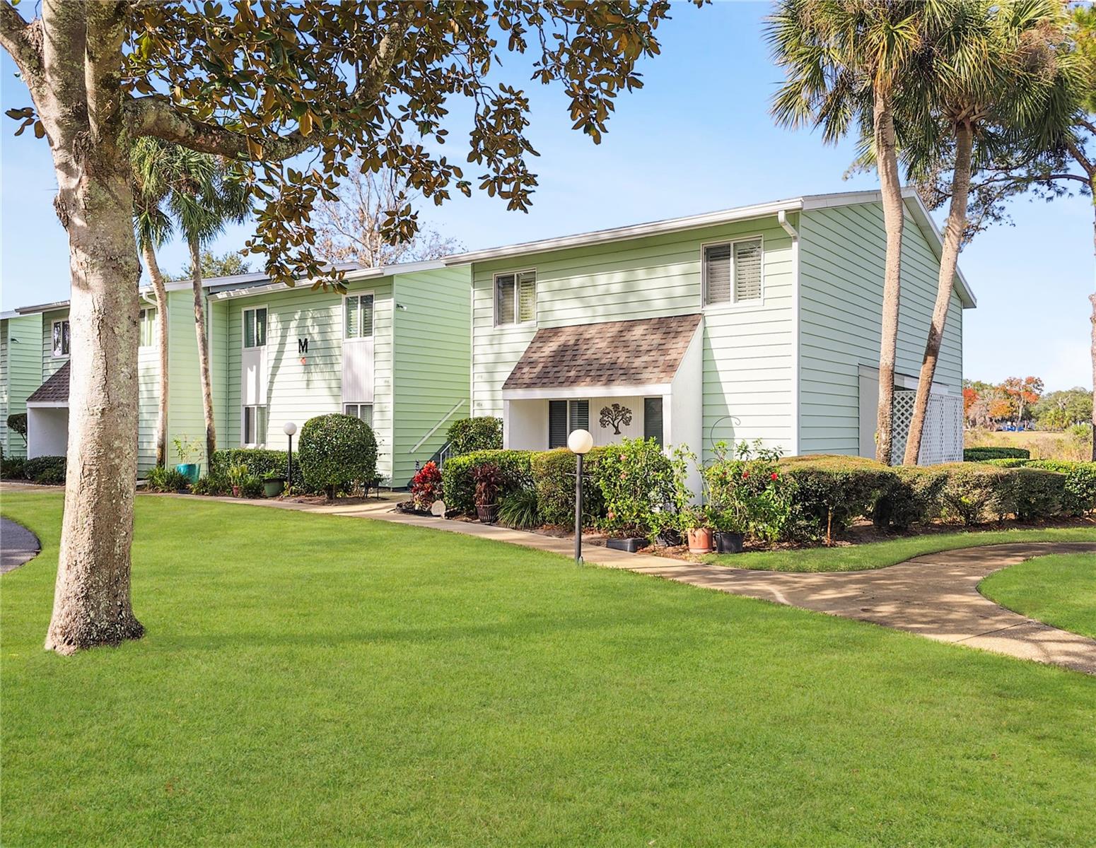 Welcome to relaxed Florida living in Live Oak Village, a 55+ community where peaceful views and everyday convenience come together. This well-maintained 2-bedroom, 2-bath condominium offers 1,138 square feet of comfortable living space, plus an additional 120 square feet in the open, updated lanai—the perfect spot to unwind while enjoying sweeping views of Lake Sparkle and the Silver Springs Shores Golf & Country Club. Inside, the home features a tasteful blend of carpeting and luxury vinyl plank flooring throughout, complemented by ceiling fans in the living area and both bedrooms for year-round comfort. The updated kitchen showcases newer appliances, modern light fixtures, and accent lighting, creating a bright and inviting space for cooking and entertaining. Both bedrooms are generously sized, with two full baths for added privacy and convenience. A washer and dryer are conveniently located in the second full bath. The building itself is tucked away on a private cul-de-sac, offering a quiet, low-traffic setting. Enjoy true low-maintenance living with HOA fees covering building insurance, exterior and common area maintenance, community pool, garbage pickup, and cable TV. Just less than five minutes away, the Silver Springs Shores Community Center offers exceptional amenities including two pools (one heated), a gym, meeting rooms, and a wide variety of activity clubs—all for an incredibly low annual fee of only $5. Whether you’re looking for a full-time residence or seasonal retreat, this lakeview condo delivers comfort, convenience, and value in one of Ocala’s welcoming 55+ communities.