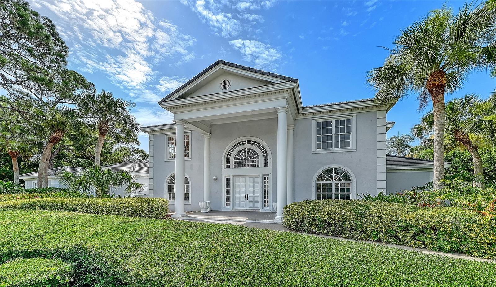 Virtually Staged. A rare canvas of luxury, positioned on a lush double lot within the sought-after, gated community of The Oaks, in Osprey, adjacent to stunning Sarasota, known for the arts.  Bordering the Heron Course on the eighth fairway, this iconic two-story estate boasts incredible opportunity for limitless potential. The entire interior is freshly painted, to enhance vision of stateliness. With five bedrooms, 7.5 baths and a sprawling layout, this magnificent property is an exceptional backdrop, just waiting for your personal touch. Arrive in style via the elegant front circular driveway or utilize the private rear driveway leading to a rare four-car garage. Inside, the home is masterfully designed for grand entertaining and everyday comfort, with a sweeping curved stairway at the entrance, setting the stage to an exquisite residence. The first floor features a formal living room and a sun-drenched family room complete with a fireplace, custom built-ins and multiple French doors, leading to the outdoor bliss. A screened lanai lays the foundation for Florida living at its finest, showcasing an enormous 33-by-46-foot sparkling heated pool and spa, expansive patio and an outdoor kitchen. The expansive open kitchen is a chef's dream, flowing seamlessly into a casual breakfast nook. For formal affairs, the large dining room offers custom cabinetry and an adjacent wet bar. The main-floor primary retreat is a sanctuary, featuring a dedicated sitting area and luxurious dual en-suite baths. There is more closet space than a clothes diva could possibly desire. The first floor is completed by a handsome office/library with built-ins, a powder room and a guest bedroom. Upstairs, you will find three additional en-suite bedrooms, one of which benefits from private back-staircase access, ideal for an au pair, in-laws or VIP guests. With every bedroom featuring its private bath, privacy is guaranteed for all. Outdoors, the walled double lot provides a private tropical oasis, all with tranquil, serene views. On a practical note, roof was replaced in 2019, with hurricane shutters, for peace of mind. Two 18-hole championship golf courses, 12 Har-Tru tennis courts (four lighted), croquet and pickleball courts, a state-of-the art fitness center, fine and casual dining options and a calendar of social events, The Oaks is Sarasota’s leading golf and country club.