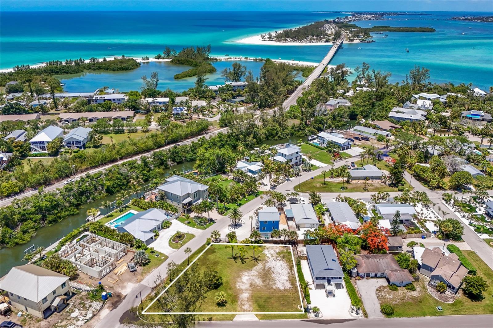Village of Longbeach — A Rare Canvas on Longboat Key's North End
Tucked into the historic Village of Longbeach, this oversized 13,242 sq ft corner lot is a quiet invitation to build something lasting. Cleared and ready, it offers the rare chance to shape a custom coastal estate, a modern island retreat, or a thoughtful investment in one of Longboat Key's most storied neighborhoods.
This is the island's tranquil north end — a beach-to-bay enclave where shell-strewn lanes wind beneath sea grape and gumbo limbo, and the rhythm of the day is set by tide charts and sunsets. Sarasota Bay lies steps in one direction, the sugar-sand shores of the Gulf in the other.
Village life here is unhurried and genuine. Neighbors gather at the community dock for the long-standing "Yappy Hour" tradition, with bay access, fish cleaning station, and boat ramp just down the lane. Mornings might begin with coffee at a waterfront café; evenings unfold over dockside dinners at Mar Vista or Shore, a short stroll or golf cart ride from your door. Whitney's, boutique shops, fishing charters, and the free trolley to Anna Maria Island's Bridge Street are all within easy reach.
Room enough for sweeping outdoor living, mature tropical plantings, and a home built around the way you want to live by the water — this is a quietly exceptional piece of old Florida, waiting for its next chapter.