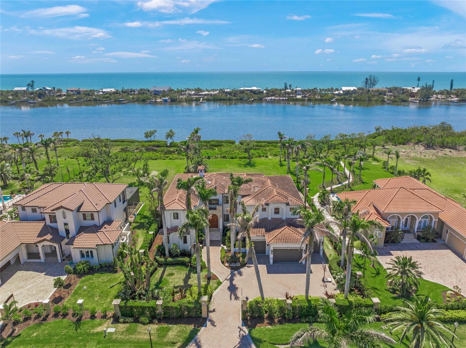 It’s always about the view and this stunning waterfront estate is an exceptional blend of Mediterranean modern luxury, coastal chic design and thoughtful functionality with impact windows and doors throughout. This all-concrete home offers a rare opportunity to enjoy unparalleled Intracoastal Waterway views from nearly every room. Set on a gated full bayfront acre parcel, this exquisite residence combines elegant design with a tranquil, retreat-like ambiance. High-end finishes are present throughout, including travertine flooring, elaborate tray ceilings, all accented by an abundance of natural light pouring in through large windows and French doors. Entering through a grand foyer 10-foot double door entry to living room with floor-to-ceiling windows overlooking the expansive yard to the bay and Manasota Key beyond. Marble wood-burning fireplace sets the focal point. The layout is ideal for everyday living and grand entertaining, with an open flow between the great room and chef-inspired kitchen. The recently remodeled kitchen is a showstopper, featuring sleek quartz countertops, a spacious single-level island with a breakfast bar and top-of-the-line stainless steel appliances, including induction cooktop, a hood, built-in double ovens and a convection microwave, and warming drawer. The extensive remodel totaling $130,000 extends to the family room with built-in seating, shelving and cabinetry topped in quartz extending the entire length of the room, to further elevate this gourmet space. Main level has its laundry room and powder room. All five bedrooms are en suite with walk-in closets. Two on main level and three upper level including the owner's suite. The luxurious baths showcase exotic tile and granite selections. A dedicated elevator offers access to upper-level bedrooms and bonus room. Owner’s suite is exquisite with marble flooring and marble onyx inlay, private screened-in balcony, spacious walk-in closets, laundry room and dual vanity rooms with separate toilets and bidet. The upper-level bonus room offers an added level of versatility, with an adjacent den/office or home gym area. Outside, the outdoor living area is equally impressive, with a heated pool, spa, extensive travertine patio space and covered sitting areas. Ideal for entertaining and enjoying magical sunset views Manasota Key. Oversized four-car garage, with high ceilings. Don't miss the opportunity to make this extraordinary estate your own. Schedule a viewing today and experience this unparalleled waterfront lifestyle. Incredible location in a gated enclave surrounded by 225 acres of preserve, minutes to sandy beaches. Some furnishings are available separately.