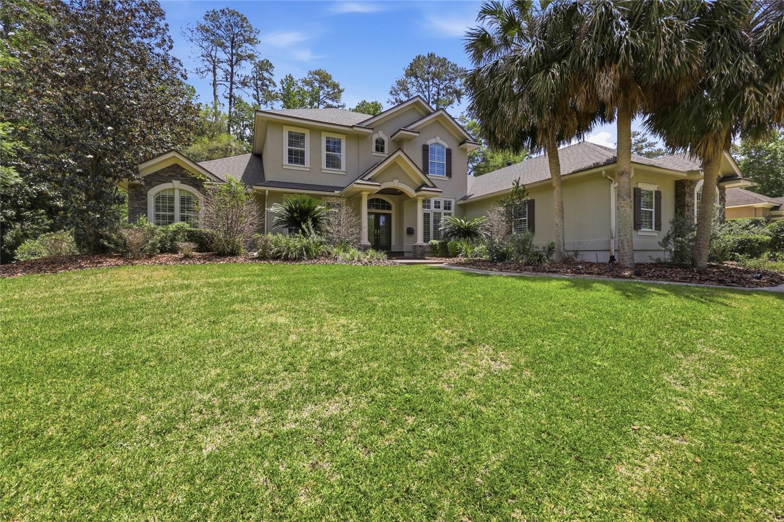 This gracious 5 bedroom 4 bath residence is situated on a beautifully landscaped .6 acre lot in the Stratford Ridge area of Haile Plantation. A winding walkway leads to double leaded-glass door, opening into a tiled entry foyer. There is a formal living room, with a mirrored wall, crown molding and French doors that open onto the screened pool and spa. The formal dining room has built-in cabinetry and display shelves. The expansive family room, with tray ceiling, also has built-in cabinets and shelves that flank a granite-faced gas fireplace. The gourmet kitchen has wood cabinets (some with glass fronts), granite countertops, stainless steel appliances, a central island with a salad sink, a gas cooktop and an adjacent breakfast room with an expansive bay window. The owner's suite has engineered hardwood floors, two large walk-in closets, a bathroom with dual vanities, a stall shower, jetted tub and an enclosed WC. There are two more downstairs bedrooms and bathrooms could be used for family, guests or as home offices. Two upstairs bedrooms and a bathroom have an additional sitting area, illuminated by two skylights skylights. The laundry room has a built-in ironing board, space for arts and crafts projects, and is adjacent to a work-study center with a wall of book shelves. The screened pool deck is covered with pavers and has a shaded sitting area and a gas grill. The fenced yard has a walking path that leads to a firepit and outdoor sitting area, surrounded by flowering trees, shrubs and palms. The Haile Village Center and an extensive network of walking paths are conveniently located to Stratford Ridge. Hawkstone Country Club offers several levels of membership for those interested in tennis, golf or the fitness center. The University of Florida, the UF Medical Center, North Florida Regional Medical Center and I-75 are all within a short drive of Haile Plantation, as are several parks and nature preserves.