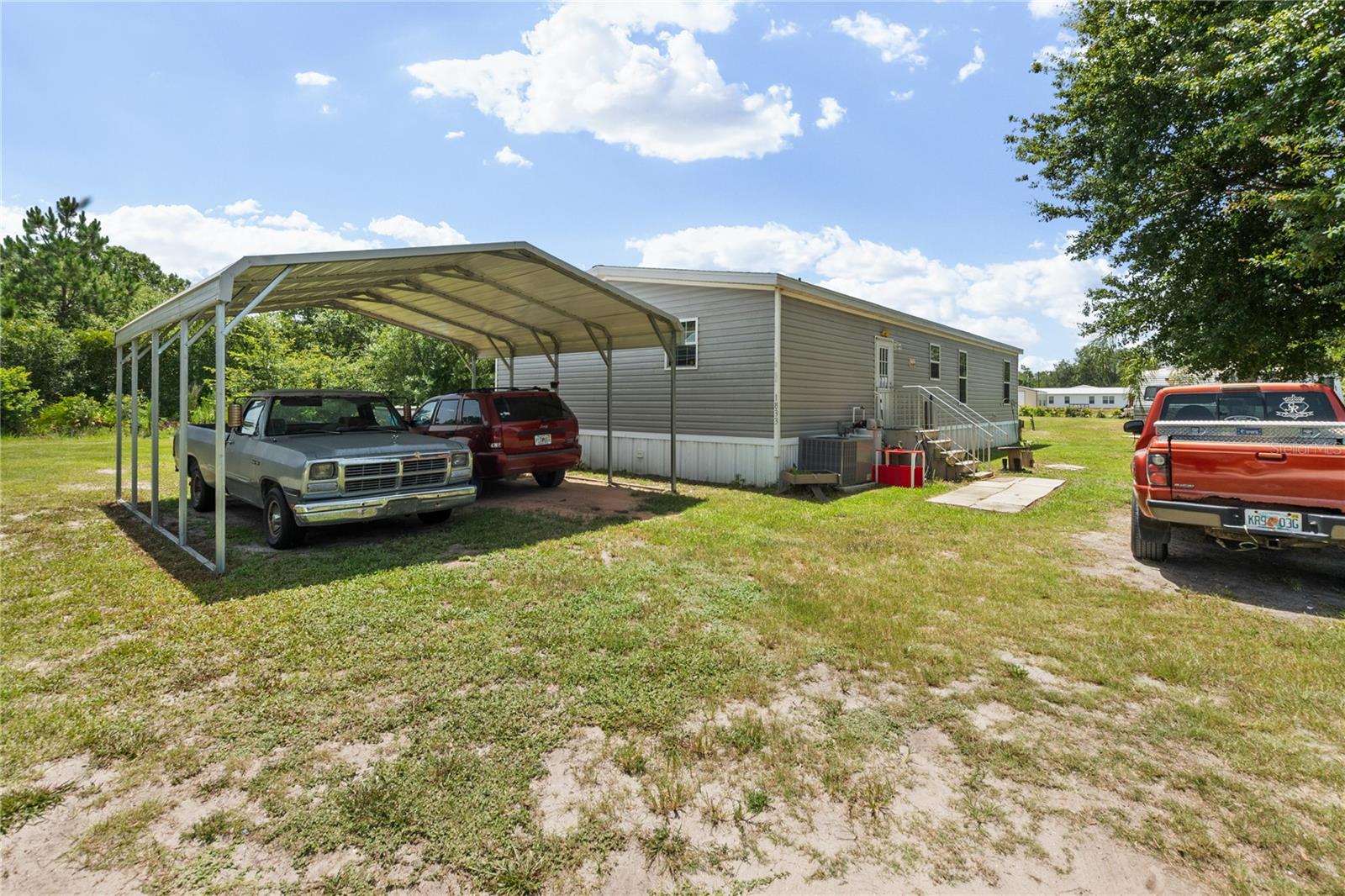 Experience the peace and possibilities of country living in this charming 2022-built manufactured home situated on a spacious 1-acre lot in Lorida. This 3-bedroom, 2-bath residence offers a wide-open living room filled with natural light, creating a bright and welcoming atmosphere for everyday living and entertaining. Barnwood-style vinyl flooring adds rustic warmth and durability throughout the home, while the modern kitchen features sleek dark laminate countertops, stainless steel appliances, a generous pantry cabinet, and a central island with breakfast bar seating. Additional upgrades include a water softener, reverse osmosis water system, submersible pump for the septic system, and a 2022 AC unit. Outside, the property offers an above-ground pool, a durable metal carport, and RV HOOKUPS FOR BOTH POWER AND WATER. A standout feature is the SCENIC POND located at the back of the property, which is owned by the seller and provides a beautiful natural backdrop with added privacy and recreational potential. The aerial view highlights the property’s expansive open space, offering opportunities for gardening, outdoor recreation, hobby farming, or future improvements to suit your lifestyle. Located in the quiet heart of Highlands County, this property combines rural tranquility with convenient access to Lake Istokpoga’s renowned bass fishing and the shopping, dining, and schools of nearby Sebring.
