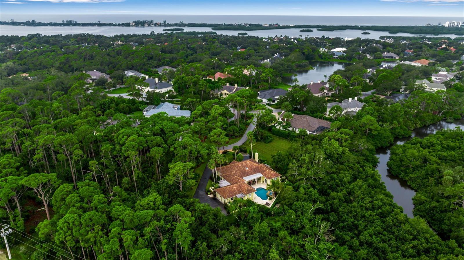 Discover incredible value and endless potential in this beautifully maintained 3 bedroom, 3.5 bath home, tucked into lush tropical landscaping, on a quiet cul-de-sac in The Oaks Bayside.  A grand traditional residence, with generous sized rooms, flexible living areas, and a private outdoor setting, the possibilities here are limitless.  Step into the marble entry through the double front doors, and you will love what you find inside. Just off the entry, a cozy den with fireplace sits opposite a spacious guest suite. The heart of the home is the light-filled great room, with formal living and dining areas opening through French doors to the covered patio and resort-style pool. The kitchen combines beauty and function with granite countertops, center island cooktop, breakfast bar, and a sunny nook overlooking the pool. The elegant primary suite offers marble floors, soaring ceilings, plantation shutters, and private access to the pool for an early swim or late-night dip. A glamorous dressing area leads to the spa-like bath with soaking tub, walk-in shower, and marble finishes. Two additional oversized en suite bedrooms provide comfort and privacy for guests. A large laundry room with ample cabinetry and an adjacent private sauna completes the interior. Outdoors, the free-form pool with rock outcroppings and waterfall is a showstopper, surrounded by both shaded and open areas for dining and relaxing. With two adjoining lots preserved as gardens, this home offers rare seclusion in a natural setting. The Oaks Club features two 18-hole championship golf courses, an award-winning tennis program, pickleball courts, a state-of-the-art fitness center and a junior Olympic, community pool as well as a celebrated social calendar, and incredible dining options. There is currently no waiting list for either Golf or Sports/Social membership