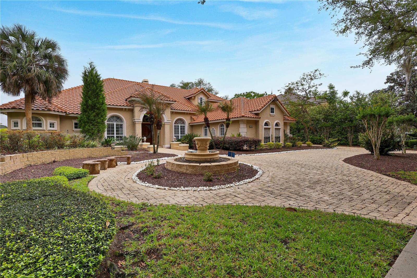 Under contract-accepting backup offers. Enjoy amazing sunsets & fireworks over Sand Lake from this exquisite European lakefront estate in guard gated Estates at Phillips Landing. Quality constructed & designed by original owners on job site daily! Over $300K in upgrades not realized in a custom builders spec home. This 4 or 5 bedrm plus office with 5 baths. 10 rooms overlook lake through double paned tinted windows accented w/craftsmanship trim & millwork. Hand carved Brazilian Oak 8ft front doors. Extensive Italian stone & Common American cherry wood flooring. Stone double sided gas fireplace in the living room & nook adds to ambiance. Faux painted ceiling treatments as well as upgraded lighting for artwork display. Gourmet island kitchen w/dramatic solid stone hood. Top of the line appliances include Advantium speed cook oven, convection microwave, cooktop, warming drawer, 48" built-in refrigerator, 2 disposals. Butlers pantry & wet bar w/icemaker. Solid natural cherrywood cabinetry w/granite countertops. Expansive breakfast bar overlooks spacious Family Room w/ quality custom built-ins & whole house stereo system which conveys as is. Sumptuous primary retreat allows for total quietness while sleeping, wake up to views of the lake through picture windows. Lavish primary bath w/garden view jacuzzi spa tub. Solid stone walk in shower. Custom cherrywood cabinetry w/granite, double vanities & bidet. 32x14 porcelain tiled covered lanai, summer kitchen, self cleaning pool & spa. Dock & boathouse leads to 10 miles of shoreline. Enjoy the privacy yet moments away from restaurants, shopping and all the attractions Central Florida has to offer..