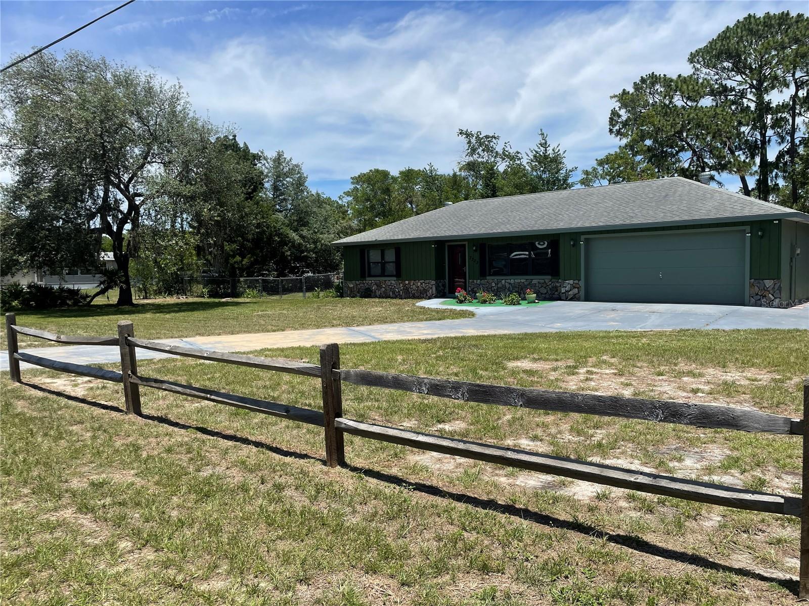 Fall in love with this immaculate 2-bedroom, 2-bath home situated on a spacious 0.62-acre lot! The fully fenced backyard offers privacy and plenty of room to enjoy the outdoors, complete with two matching storage sheds—one equipped with electric service (currently disconnected).

From the moment you arrive, you'll appreciate the pride of ownership reflected throughout this well-maintained property and its beautifully landscaped yard. A spacious 17' x 14' screened room was added in 2020, creating the perfect space for relaxing or entertaining year-round.

The large, open kitchen was updated a few years ago and features newer appliances. Additional updates include energy-efficient double-pane windows installed in 2020 and waterproof vinyl flooring throughout the main living areas.

Enjoy peaceful views of nature from the screened back porch, or make use of the versatile bonus room equipped with its own split unit A/C, currently used as a music room but ideal as a home office, guest room, hobby space, or potential third bedroom.
As an added bonus Garage has it's own Split unit A/C making the potential for a great opportunity to build out a master suite with private bath or game room , the seller is including the LG Thin Q Smart washer and dryer, along with the extra refrigerator located in the garage.

Major improvements provide peace of mind, including a dimensional shingle roof installed in 2012 and a newer A/C system replaced within the last two years.

With NO HOA and NO deed restrictions, you'll have the freedom to truly make this property your own. Bring your imagination and re-imagine this wonderful space to fit your lifestyle!