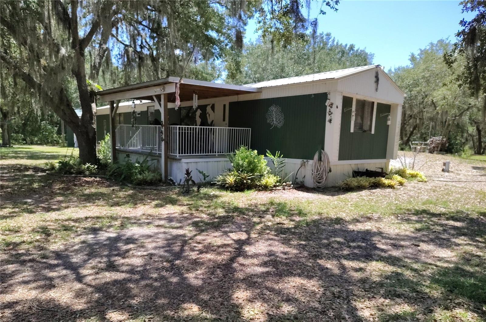 We are looking for a buyer weary of snarling traffic, HOA’s and communities of row upon rows of look alike housing.  One who is longing for their own private space surrounded by nature.  One who is dreaming of the peace that just seems to flow over you when you step from your car onto your own completely fenced 3 acres of the shade of beautiful trees and dappled sunlight and vibrant plants everywhere. If this sounds like you, you may have found your new home. Of course there is much more.  The 2 bedroom mfr home has been updated to move in ready perfection, featuring an open floor plan, roomy split bedrooms, each with baths and an updated kitchen that features custom built soft close cabinets.  To service the kitchen and baths there is upgraded electrical, (200 amp), a brand new water pump, a filtration system, reverse osmosis, and a new lift station.  The front porch is covered and shaded - ready for relaxing.  And the back deck is amazing.  It has been added with the thought of eventually becoming the beginning of a new home,  It measures 16ft by 32 ft, and has real wood plank flooring.  Oh yes, and then there is the 20 ft x 60 ft shop.  Two roll up doors, power, storage cabinets, fans.  Owners choice as to how to use this dream.  It also houses an EV charging station.  There is so much more.  For instance, the She Shed, It is so roomy, 16 ft x 16 ft, with power, AC and full length mirrors on one wall, high ceiling with beautiful lighting.  It sits  all alone, away from the house out by the tree with the ladder up to the almost hidden chair in position for hunting or just gazing on all the surroundings.  The acreage is beautifully cleared and completely fenced. Safely keep your horses, cows, goats, dogs.  And we must not forget the stocked pond created by the current owner.  Estimated 100 ft by 30 ft with a solar powered feeding system that feeds the tilapia and catfish.  This unique property is a must see.  Call today for your appointment.