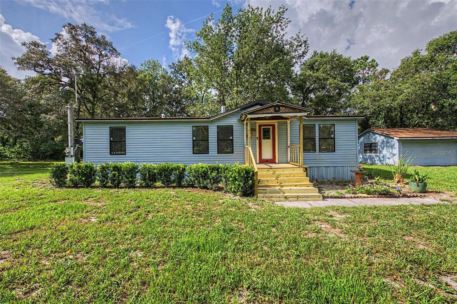 PEACEFUL COUNTRY LIVING | BEAUTIFULLY UPDATED 3 BEDROOM HOME | 1 ACRE HOMESTEAD | DETACHED GARAGE/WORKSHOP | PRIVATE ROAD | Escape to your own private acre in Hudson, Florida! This beautifully updated 3-bedroom, 2-bath manufactured home offers the perfect blend of modern updates and peaceful country living with no HOA restrictions. Inside, you'll find an inviting layout featuring luxury vinyl plank and tile flooring, a cozy wood-burning fireplace, and a beautifully remodeled kitchen complete with quartz countertops, soft-close cabinets and drawers, a stylish tile backsplash, stainless steel appliances, and a convenient breakfast bar that's perfect for casual dining or entertaining. The spacious primary suite includes a large bathroom and walk-in closet, while a newer HVAC system, new well pump, and water filtration system provide added peace of mind.  Outside, enjoy the privacy of the one-acre homesite surrounded by mature trees. Gather around the firepit, unwind in the gazebo, or make the most of the detached two-car garage and additional storage sheds, offering plenty of room for vehicles, hobbies, tools, and outdoor equipment. Conveniently located with easy access to SR 52, shopping, restaurants, medical facilities, and the Suncoast Parkway, this property offers the tranquility of country living while remaining close to everyday conveniences. Whether you're searching for your first home, downsizing, or simply looking for more room to spread out, this move-in-ready property is one you won't want to miss.