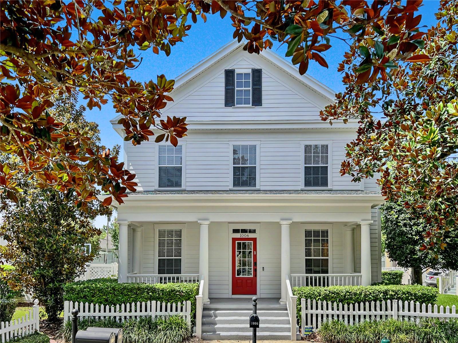 Welcome home to 1006 Sandlace Ct, a fully remodeled retreat on a rare oversized lot in the heart of East Village. A full front porch sets the tone here, offering quiet park views and the kind of evening front-porch living Celebration was built for. Step inside to wide plank shadow hickory luxury vinyl flooring and 5" baseboards that carry throughout the main level, opening into a light-filled living room with vaulted ceilings and oversized windows framing sunset views over the sprawling backyard. The living space flows directly into a chef's kitchen built for entertaining. Custom 48" two-tier white shaker cabinets with glass upper doors, brushed nickel hardware, and Venetian Gold granite counters pair with a subway tile backsplash, under-cabinet lighting, and a Delta Essa touchless pulldown faucet. The Samsung stainless suite includes a French door refrigerator, built-in double oven/microwave, glass cooktop, and Broan under-cabinet range hood. A first-floor office or fourth bedroom option adds flexibility for work-from-home buyers or multigenerational living. Upstairs, the same shadow hickory flooring continues into a primary suite that feels like a private escape. The spa-inspired bath features dove grey wide ceramic tile, a frameless walk-in shower with pebble stone flooring, and a dual-sink white shaker vanity topped in Carrera marble. A California Closets-outfitted walk-in closet completes the suite. Two secondary bedrooms share a beautifully finished second bath with dark harbor grey tile, a blue shaker vanity, and quartz counters. Outside, the oversized lot delivers what most East Village homes can't: a regulation half-court basketball court, white vinyl fencing, and a 2-car garage with EV hookup, all just a block from the East Village Sports Field and Pool. Come experience the town that Walt Disney World built. This location puts you close to walking trails that lead straight into a bustling downtown full of great restaurants, bars, coffee and ice cream shops, and specialty retail, all just minutes from your front door.  Don't Miss Our Video Tour!