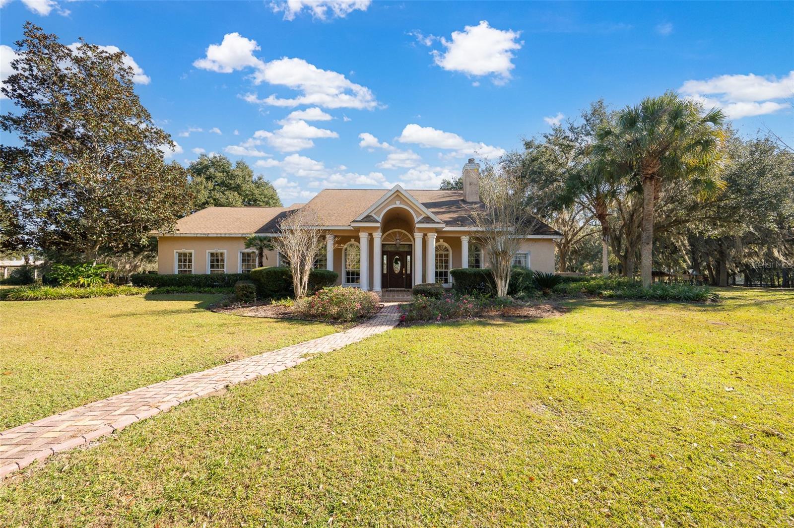 Experience refined country living on this 41-acre slice of heaven that offers a rare blend of residential comfort and equestrian facilities. This property, situated in Marion County’s soil-rich, rolling farmland, is a serene sanctuary where peace, beauty, and comfort come together.  Located in the heart of NW Ocala's ''Golden Corridor.''
Custom residence (3,190 SqFt) Exceptional and inviting, the home features an expansive open layout anchored by a dramatic double-sided wood-burning fireplace and an elegant library/sitting room/den with custom built-ins. There is also an additional living room space on the opposite side of the fireplace, complete with a convenient wet bar. The gourmet kitchen offers rich oak cabinetry, granite surfaces, and a sunlit breakfast nook. This home features three large en-suite bedrooms, including a serene primary retreat with a charming bay window and a spa-inspired bath with a functional vanity space, stand-up shower, and walk-in tub. Step outside to enjoy sweeping views from the tranquil, screen-enclosed pool. Spacious 3-car garage. Plus, a whole-house generator is included for added peace of mind.
Equestrian Facilities:
Main Barn: 14-stall concrete block center-aisle barn with office, feed/tack room, wash racks, restrooms, laundry area, and private studio apartment. A 50' x 75' covered arena with shredded rubber footing.
Additional Amenities: 4-stall frame barn with water/electric, round pen, large equipment/storage building, and a 1985 2/2 mobile home. A charming mix of banana, pear, peach, and grape trees adds natural beauty and fresh fruit right at your fingertips
All just 17 minutes from WEC and HITS—A perfect mix of comfort, convenience, and equestrian living. Schedule your private tour today!